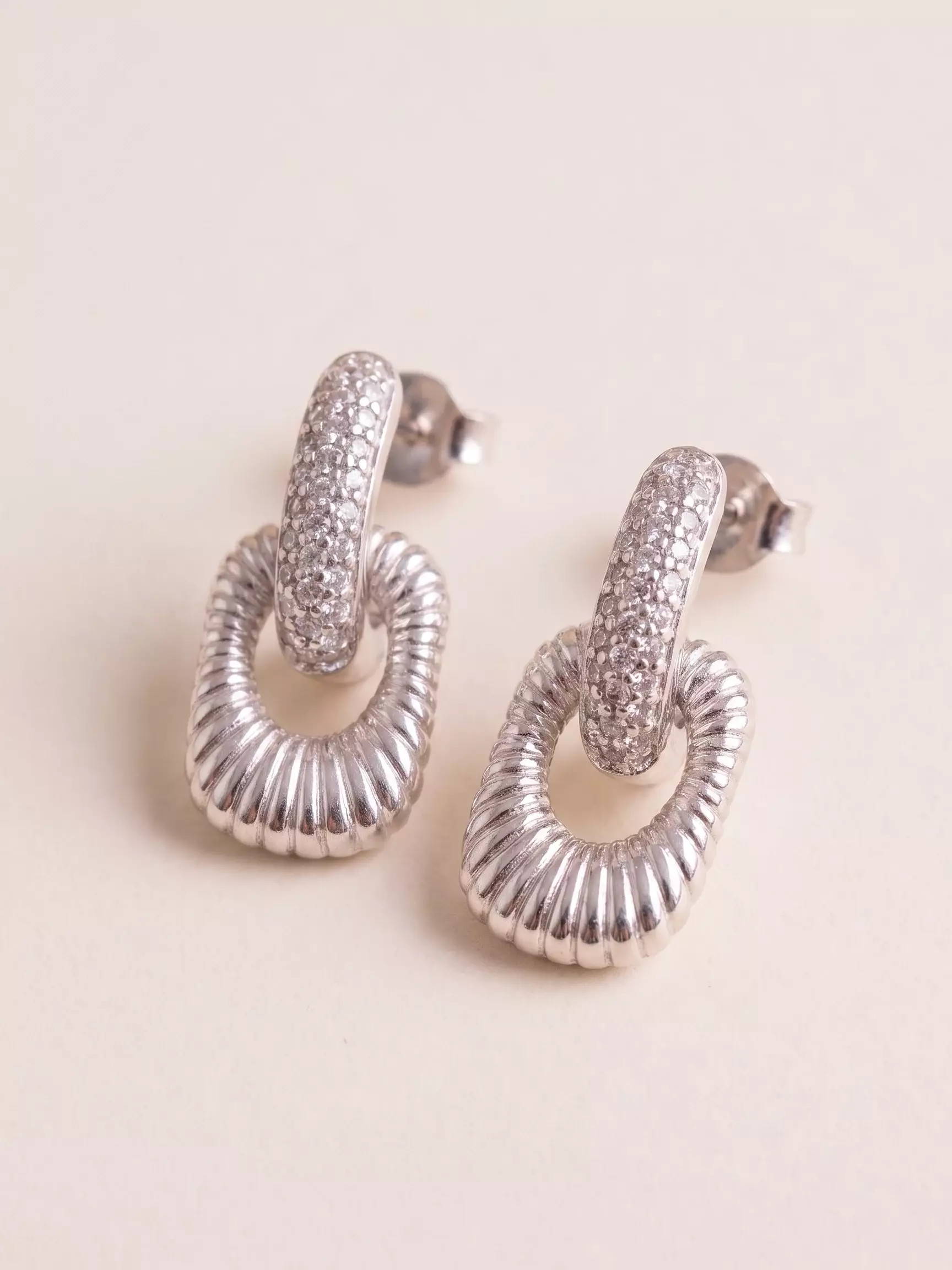 Boucles d'oreilles bâtonnet serti, rectangle ajouré détaillé finition argentée, la paire posée, vue de près