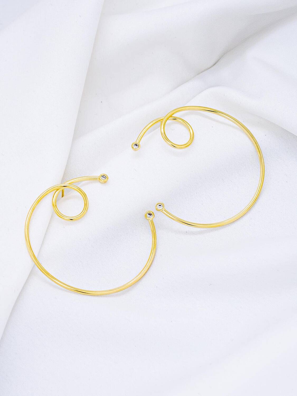 Paire de grandes boucles d’oreilles dorées en cercle ouvert et spirale, petites pierres claires aux pointes