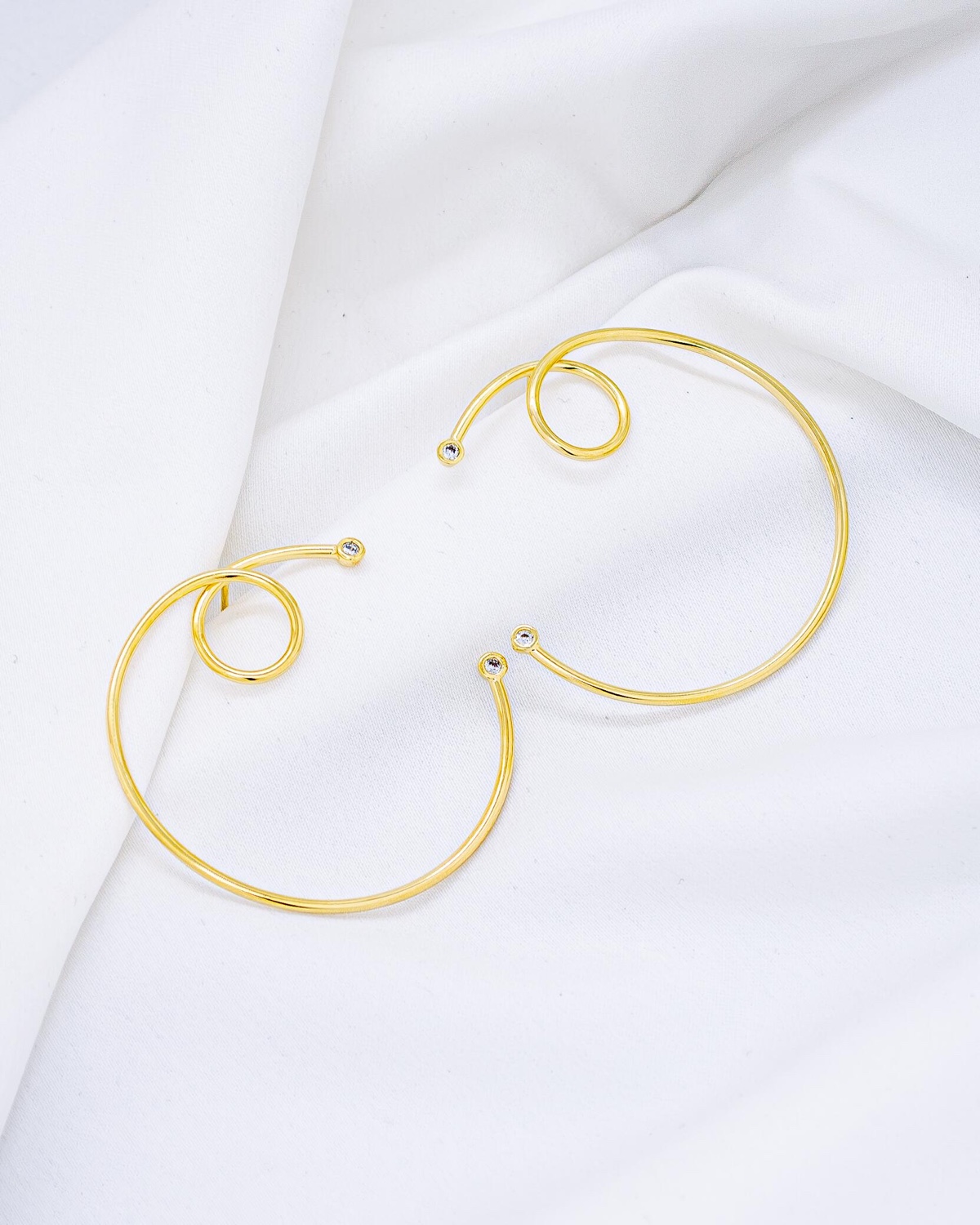 Paire de grandes boucles d’oreilles dorées en cercle ouvert et spirale, petites pierres claires aux pointes