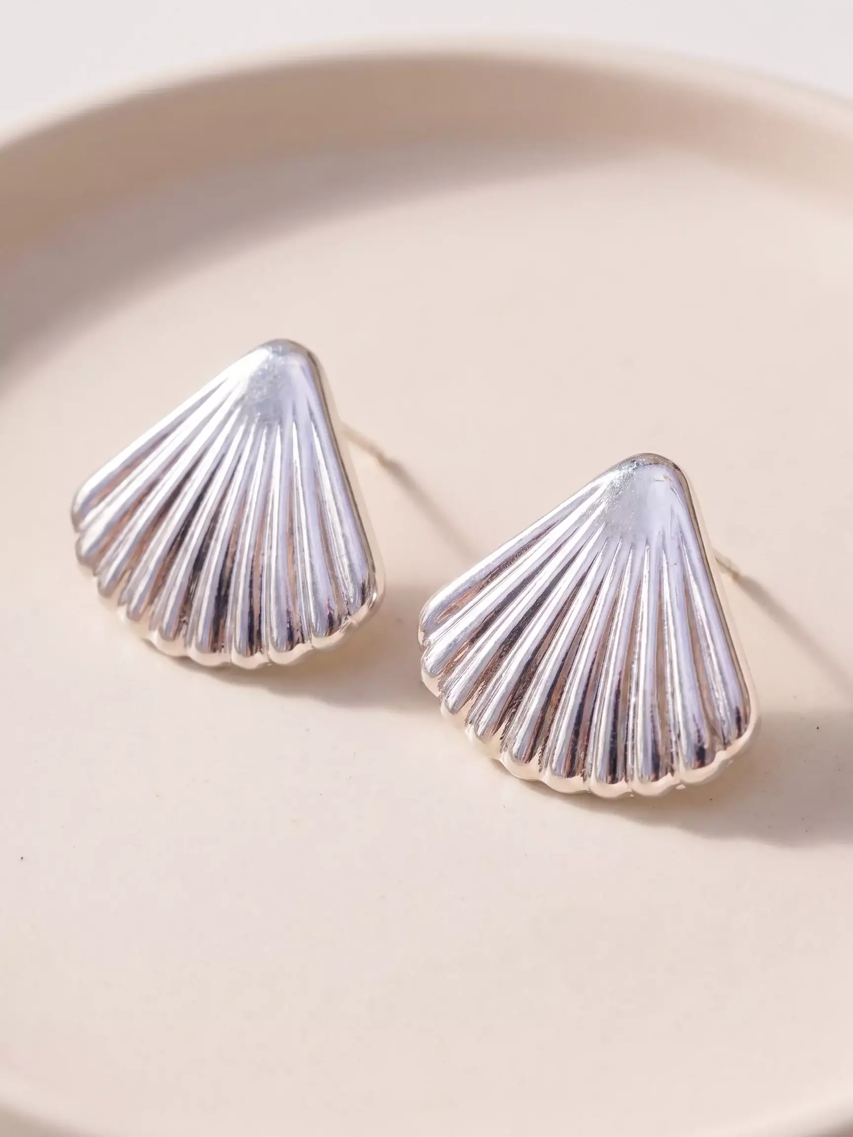 Textured shell earrings, silver finish, pair display, close-up view