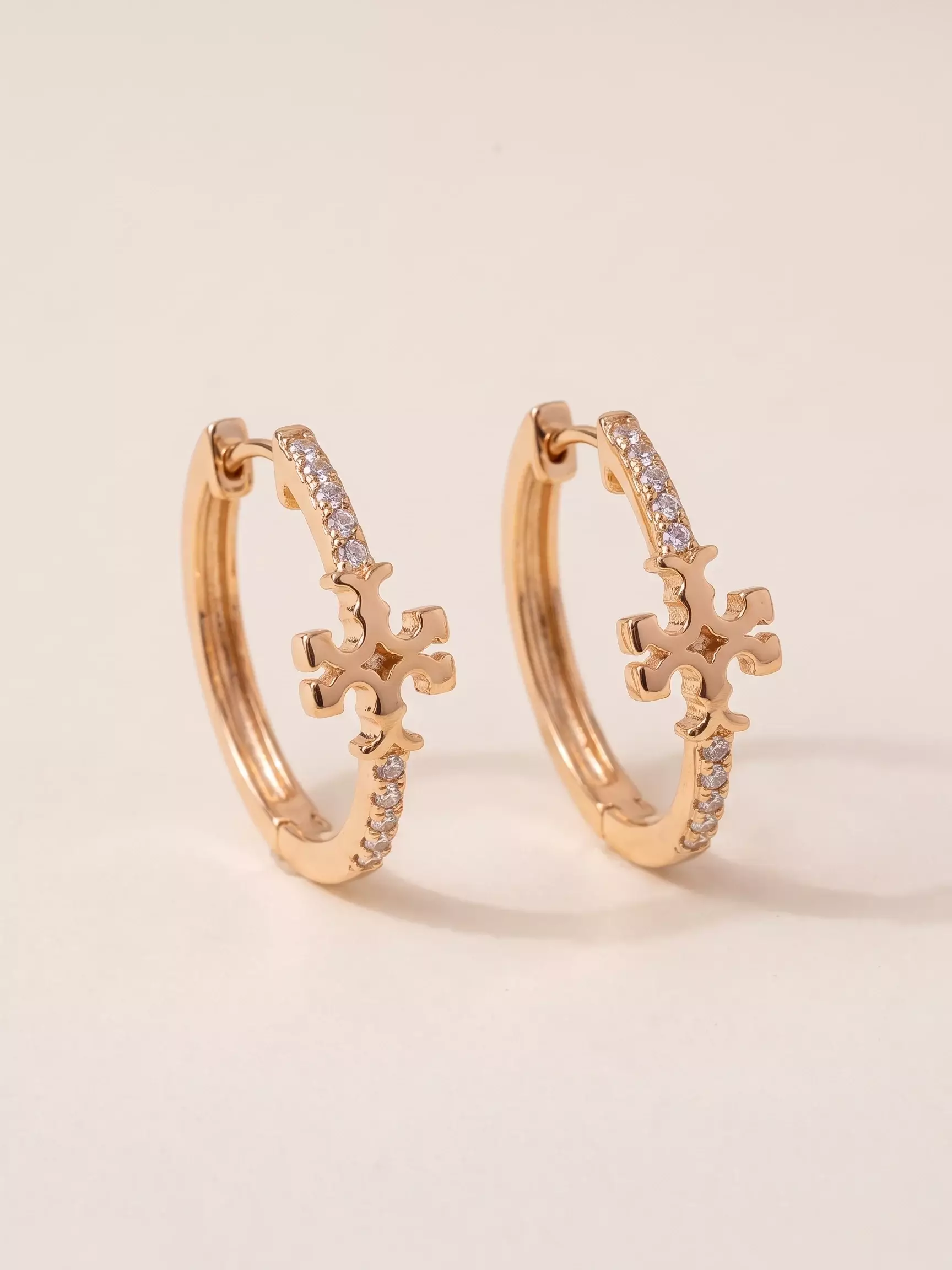 Boucles d'oreilles créole sertie, trèfle stylisé, la paire posée, vue de près
