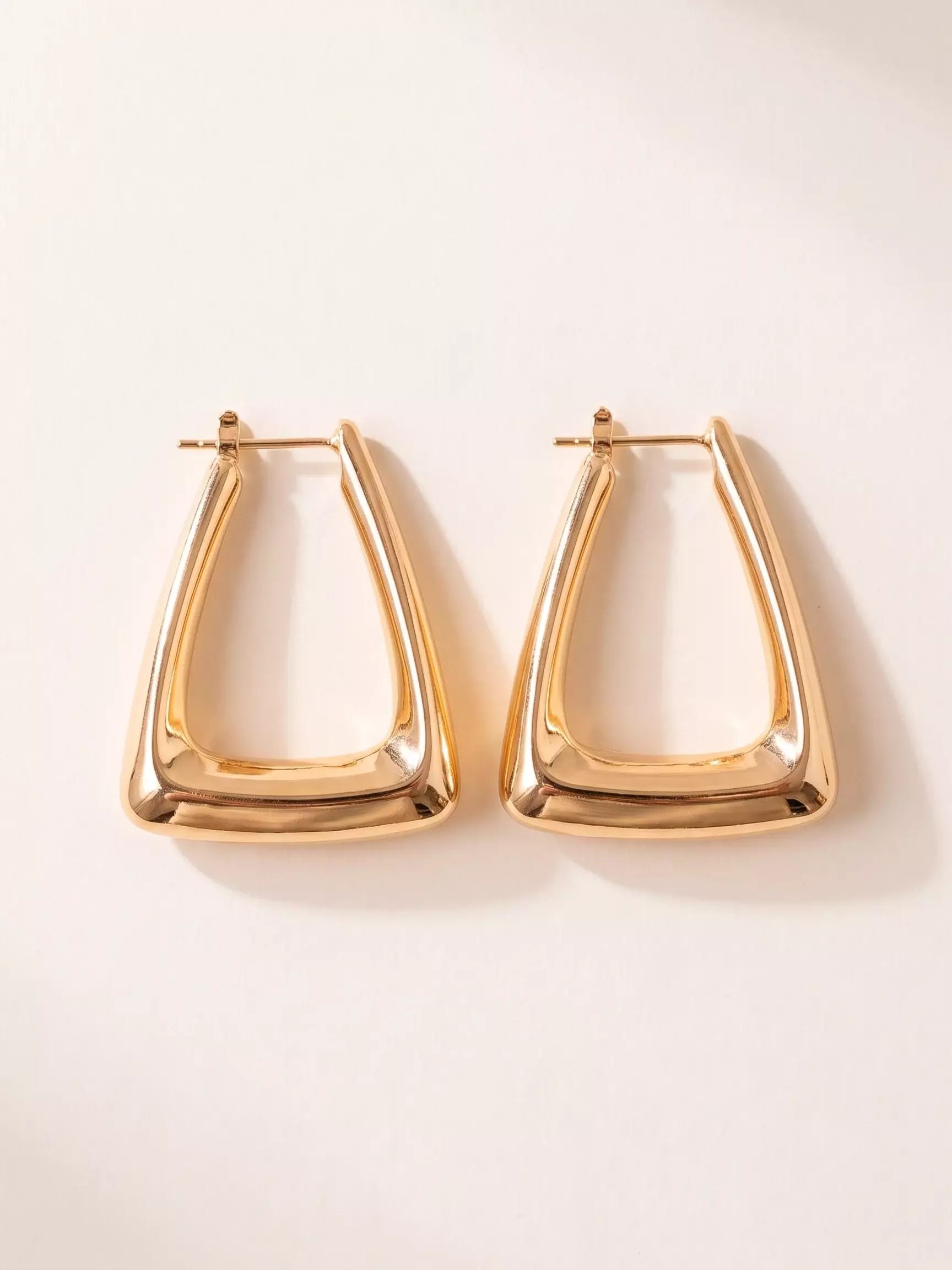 Boucles d'oreilles créole triangle, la paire posée, vue de près