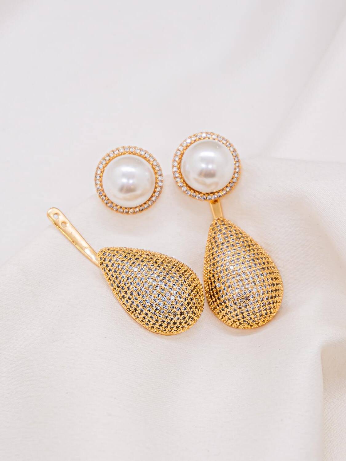 Boucles d’oreilles dorées : perle blanche cerclée de pierres claires et grande goutte pavée détachée