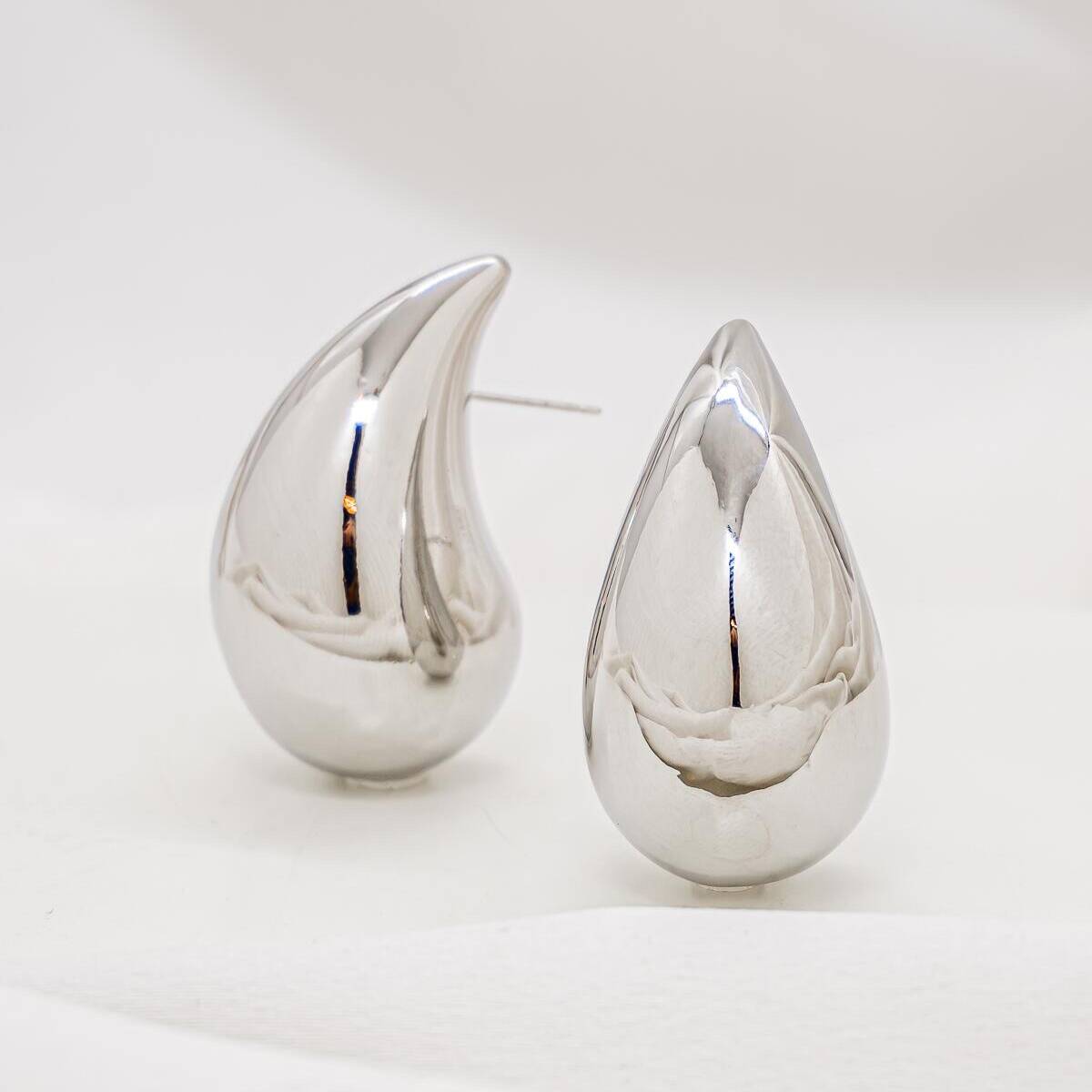 Pair of silver domed teardrop earrings, with a mirror-polished surface.