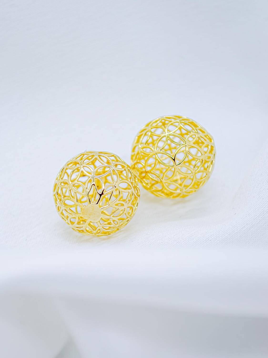 Paire de boucles d’oreilles dorées en forme de boule ajourée à motifs de filigrane