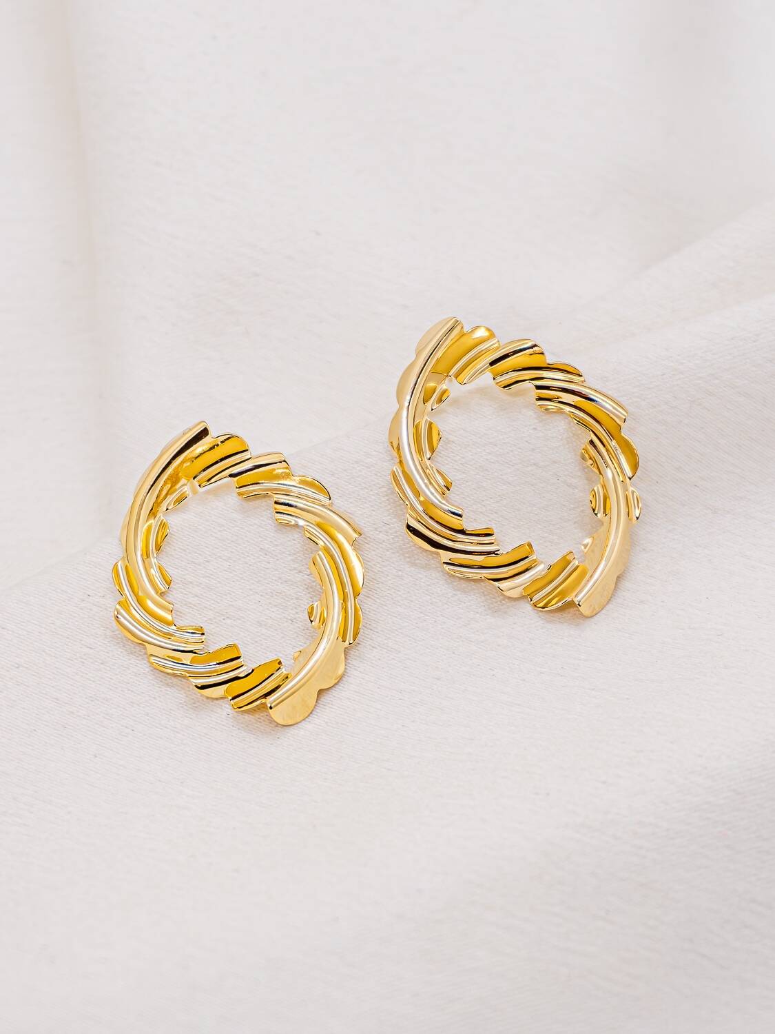 Paire de boucles d'oreilles dorées en losange ajouré aux reliefs ondulés