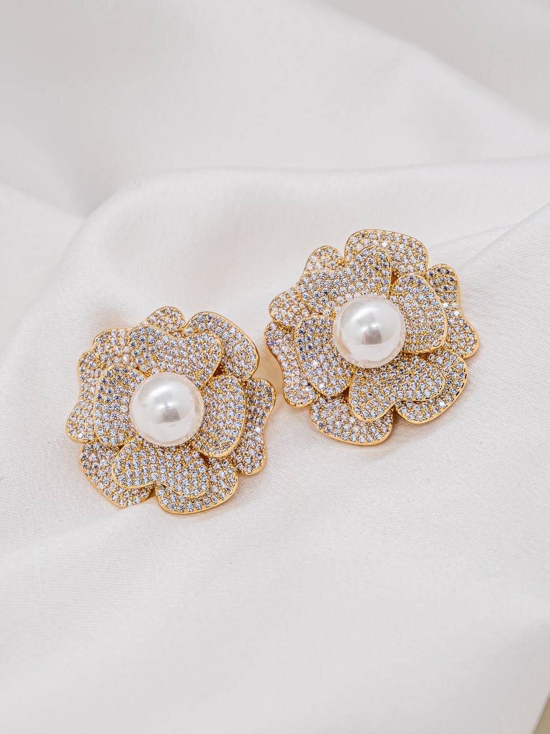Maxi boucles d’oreilles fleur dorées, pétales pavés de pierres claires et grande perle blanche centrale