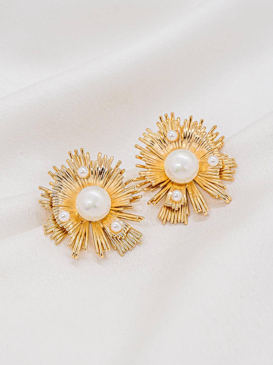 Maxi boucles d’oreilles dorées en rayons autour d’une grosse perle blanche et de petites perles