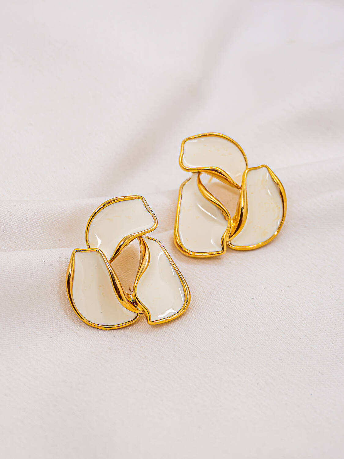 Paire de boucles d'oreilles organiques en résine blanche cernée d'or