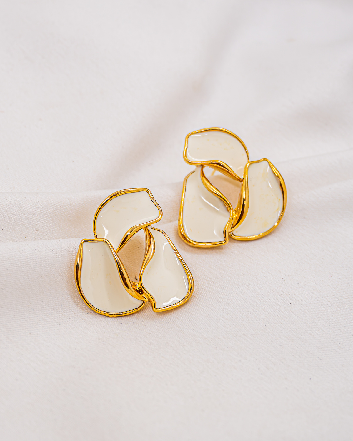 Paire de boucles d'oreilles organiques en résine blanche cernée d'or