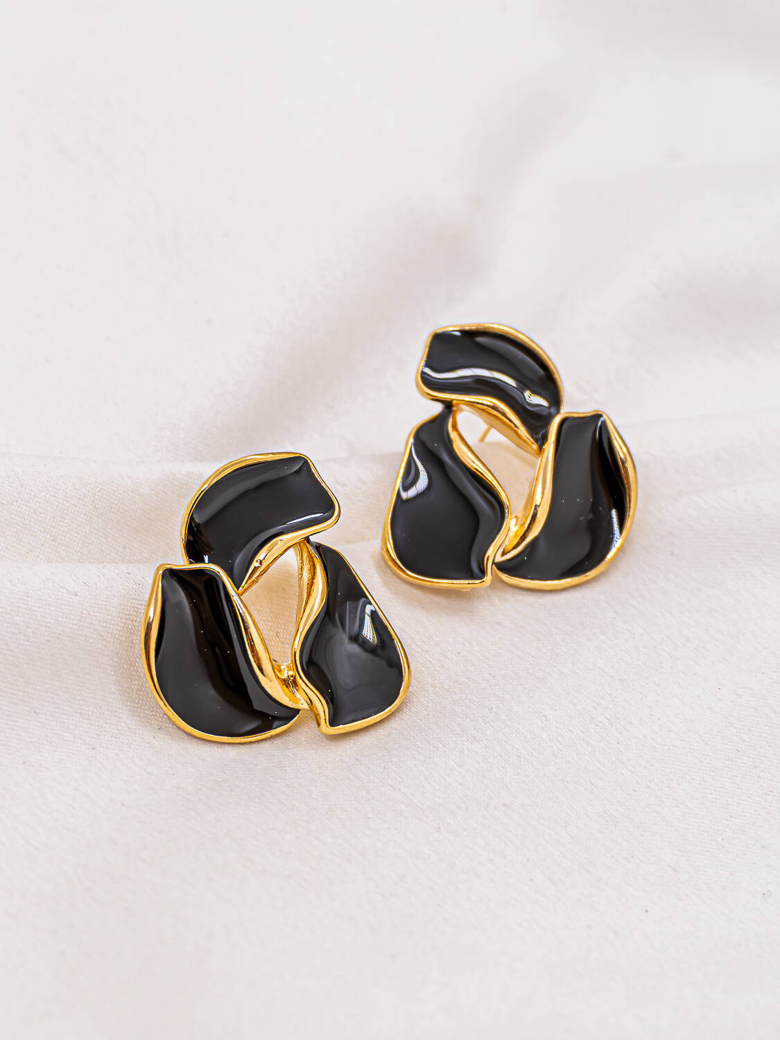 Paire de boucles d'oreilles organiques en résine noire cernée d'or