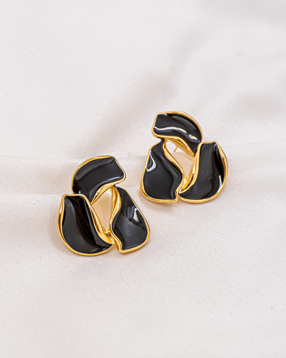 Paire de boucles d'oreilles organiques en résine noire cernée d'or