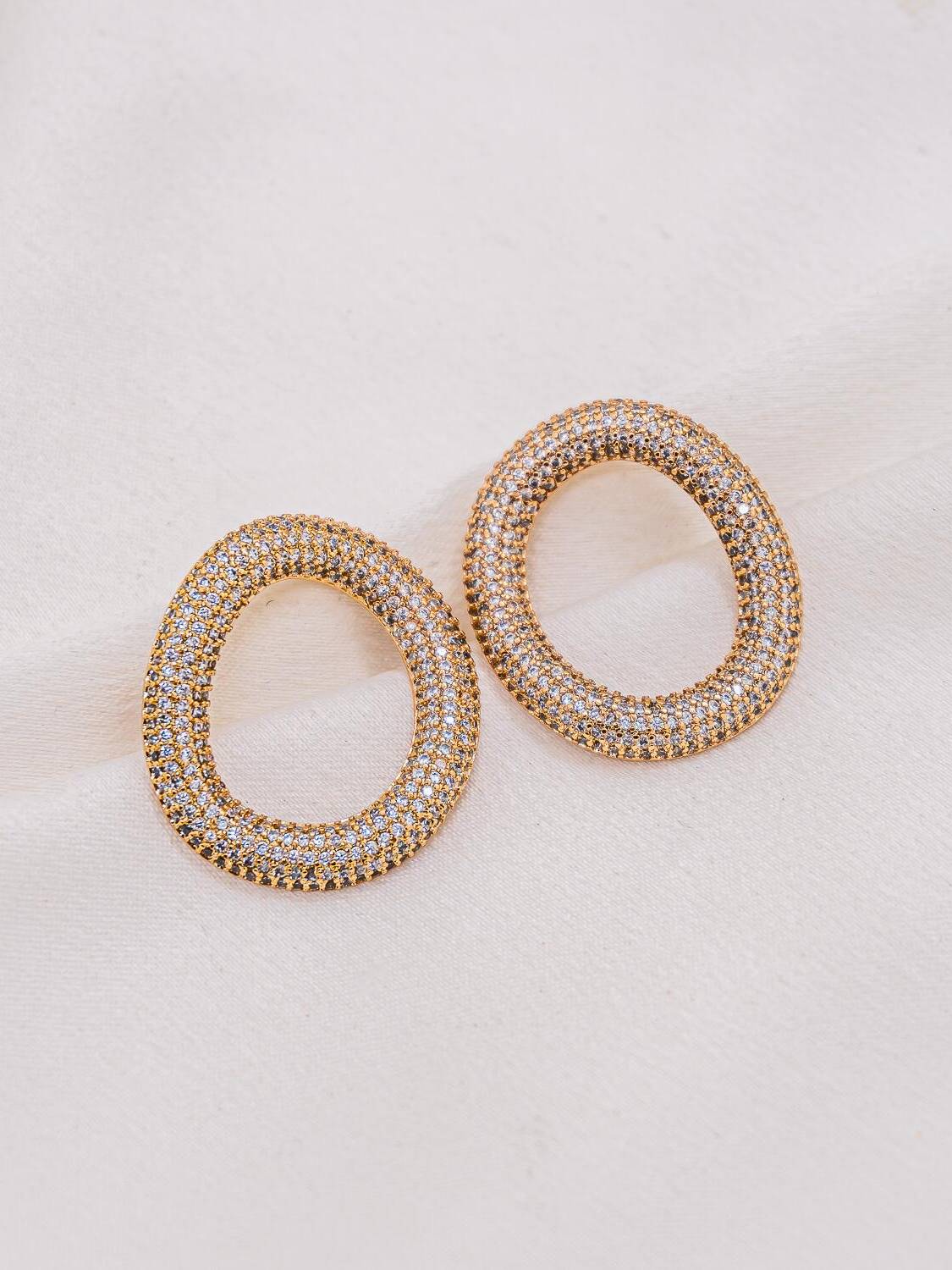 Paire de boucles d’oreilles en ovale ajouré doré, entièrement pavées de petites pierres claires