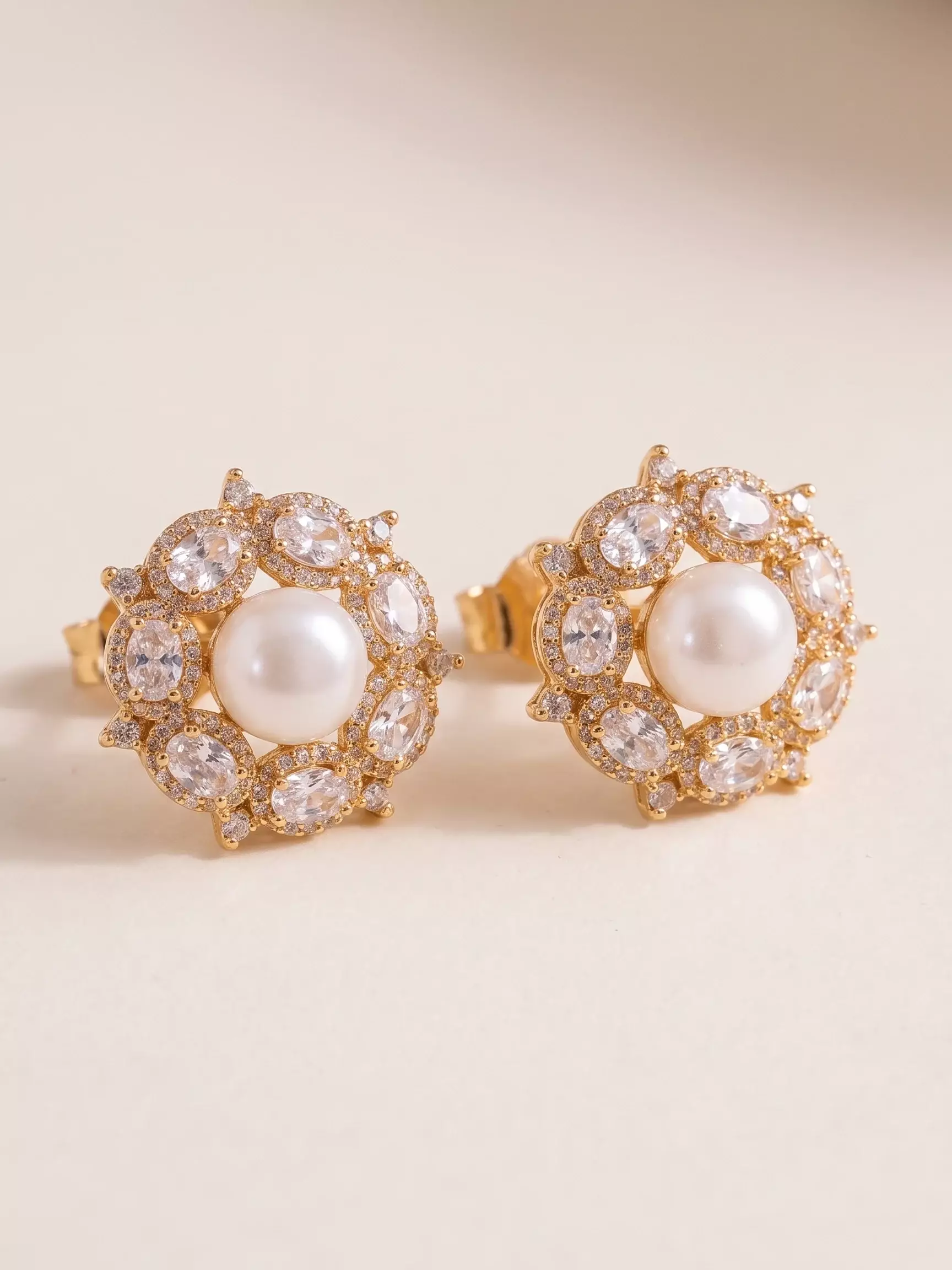 Pearl centerpiece earrings with oval zircon border, paired, close-up view
