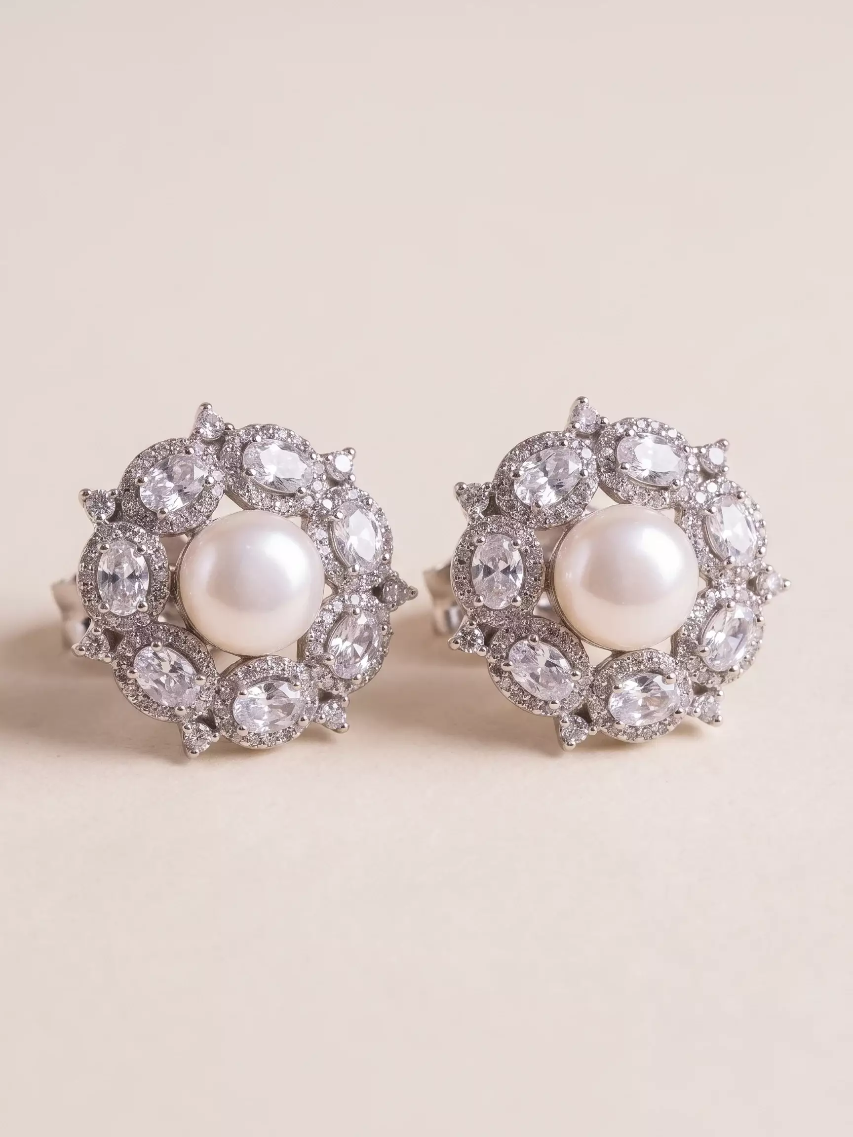 Central pearl earrings with oval zircon border in white rhodium, pair display, close-up view