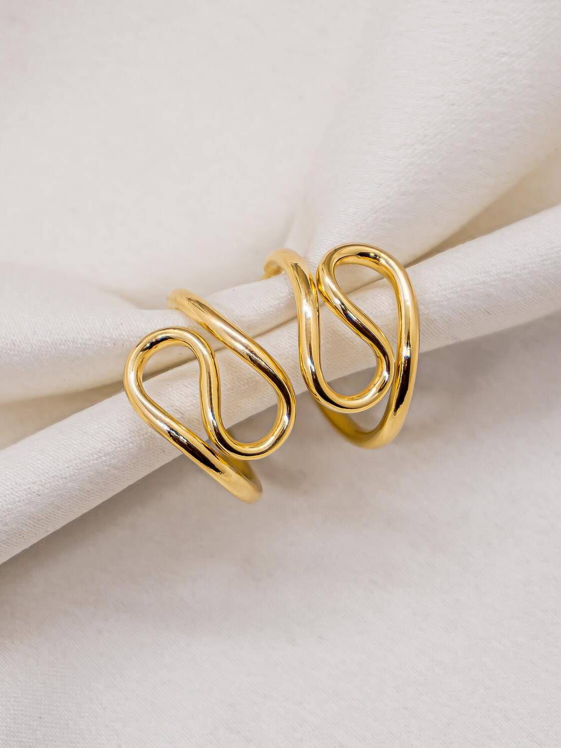 Paire de petites créoles dorées lisses dont le fil forme une boucle en spirale