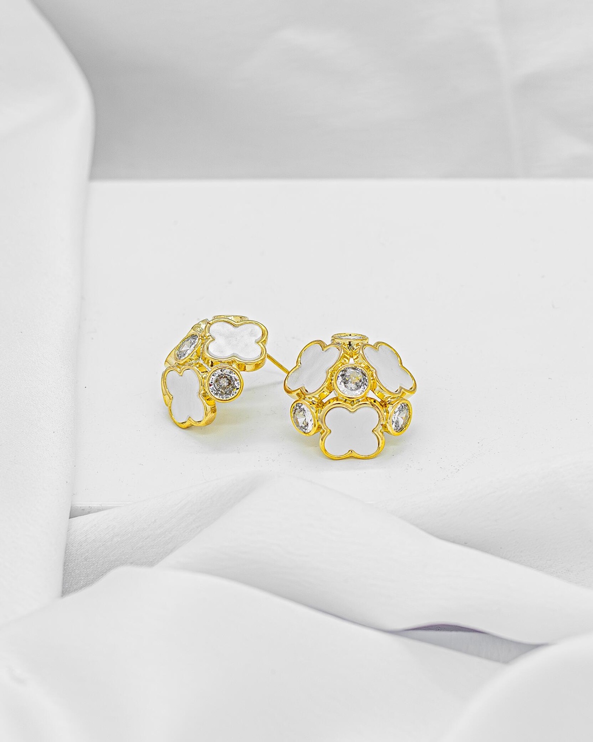Paire de boucles d’oreilles dorées en bouquet de trèfles blancs et pierres claires serties