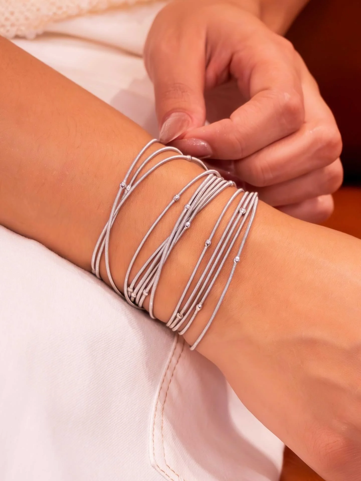 Pulseira corda de violão de várias voltas, mini bolinhas ródio branco, usada em close-up