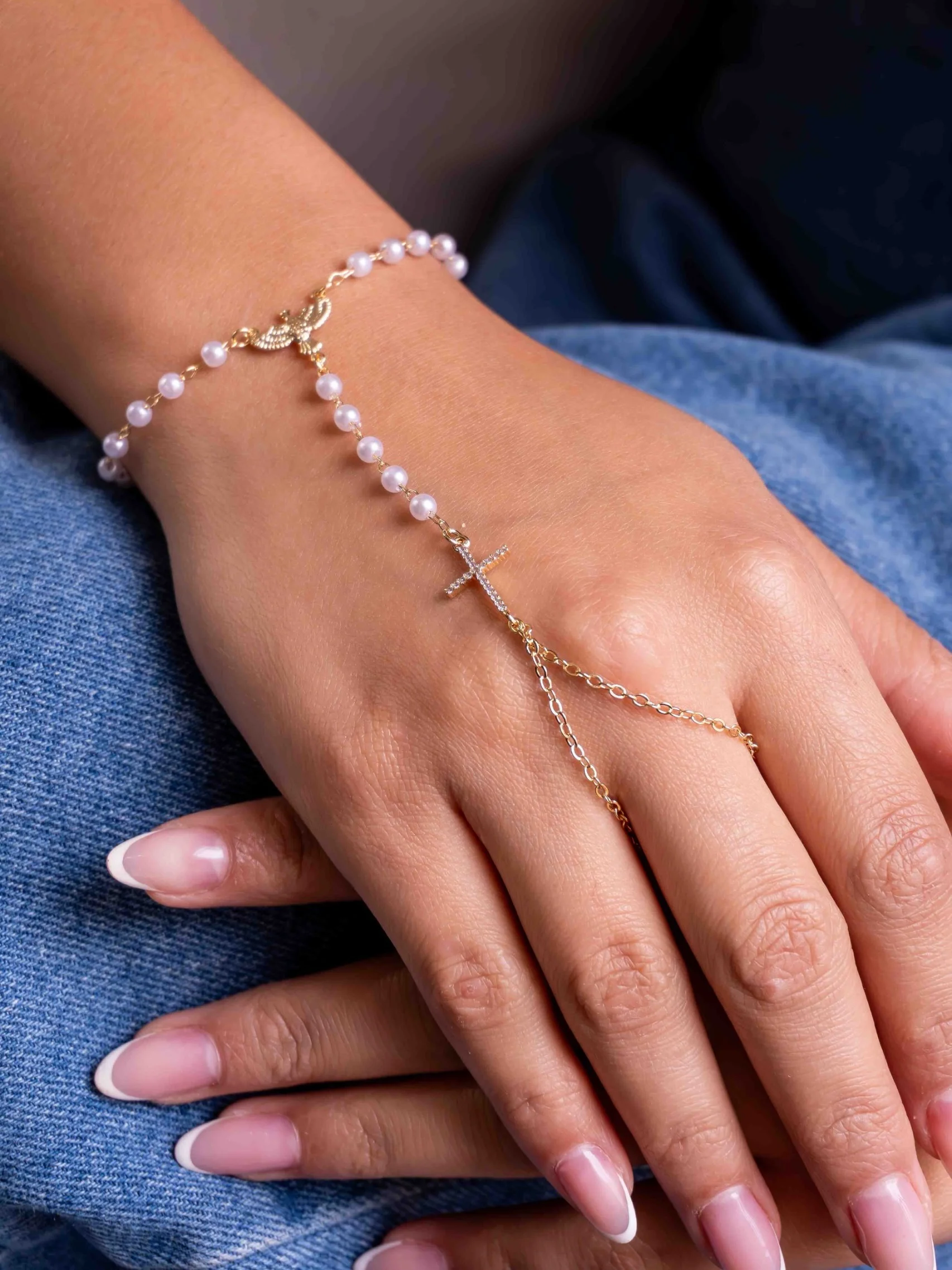 Bracelet de main perles, Saint-Esprit et croix sertie, porté en gros plan