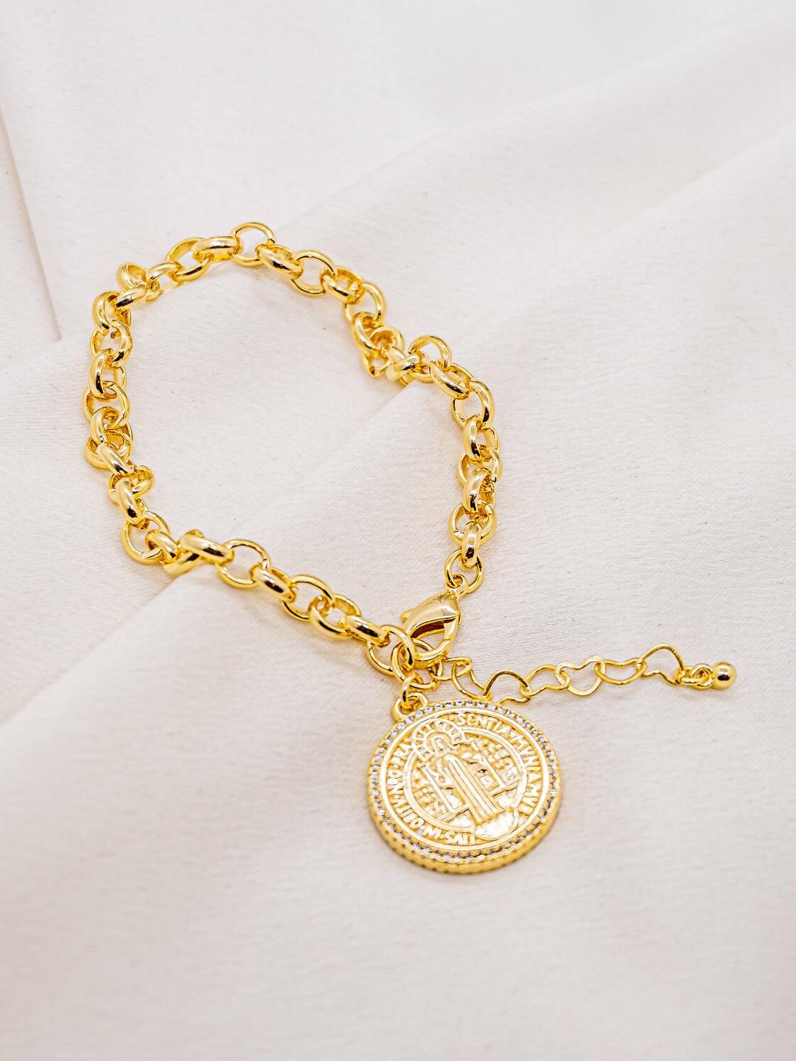 Bracelet doré à gros maillons ronds, médaille Saint Benoît bordée de pierres claires