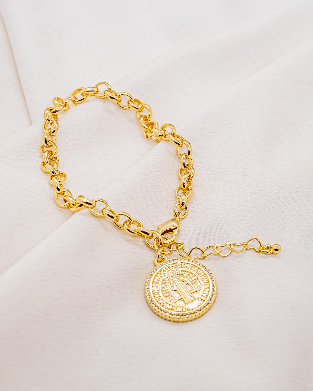 Bracelet doré à gros maillons ronds, médaille Saint Benoît bordée de pierres claires