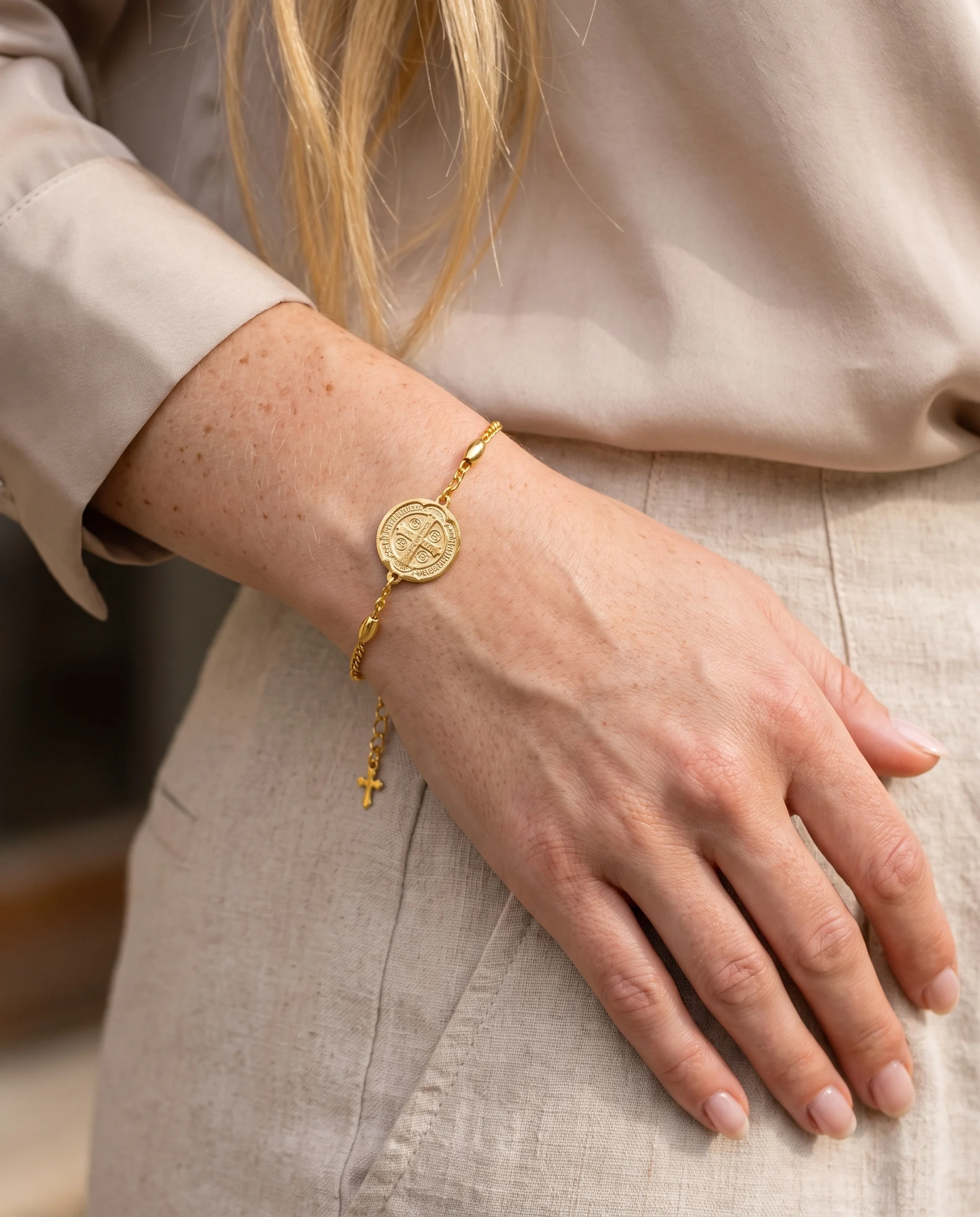 Bracelet maillons grain de riz, médaille Saint Benoît, porté au poignet, vu de près