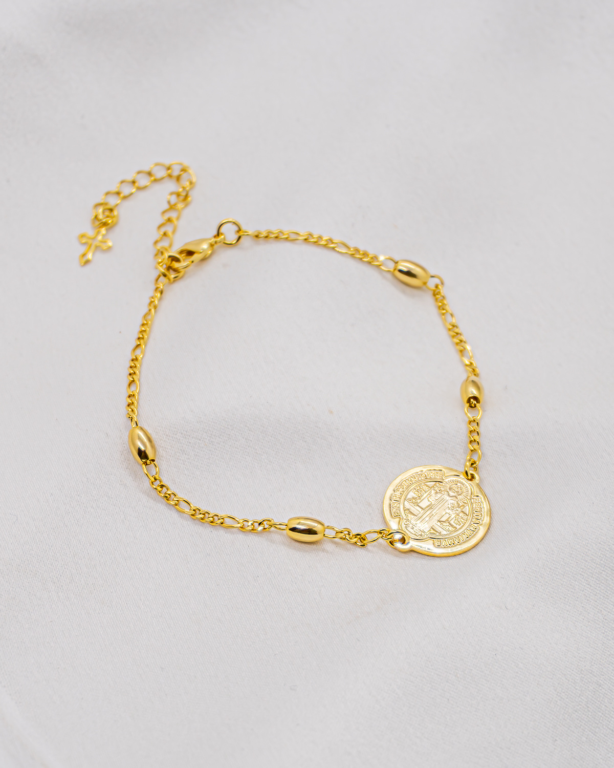 Bracelet doré à petites olives de métal, médaille ronde de Saint Benoît et petite croix