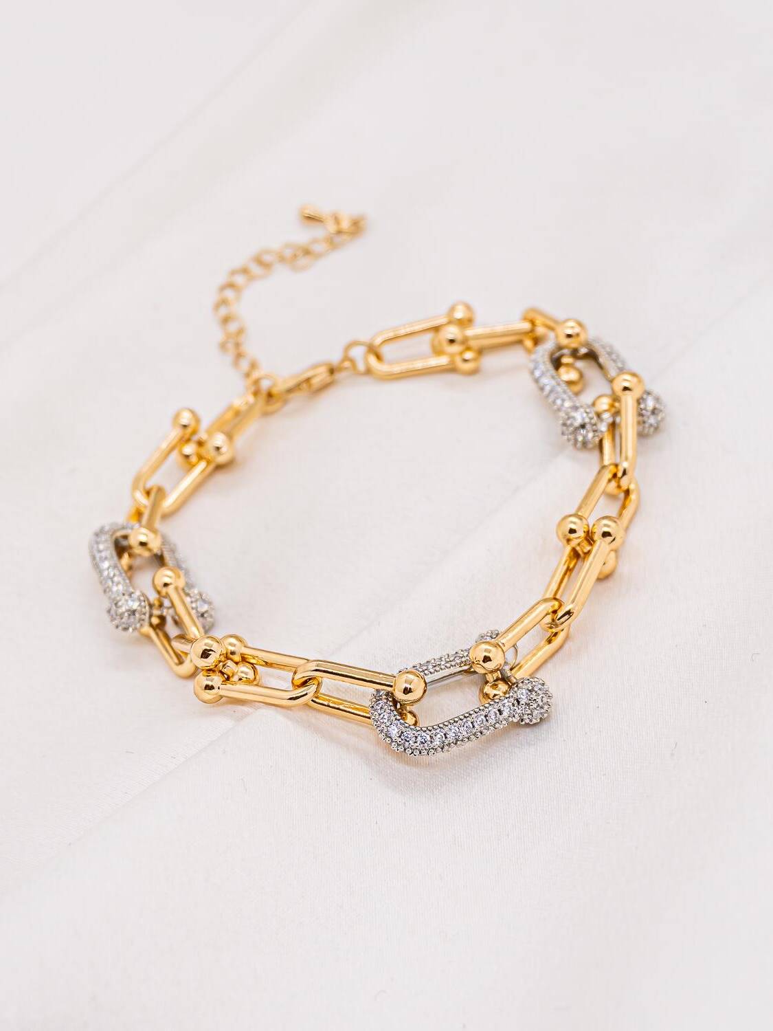 Bracelet à gros maillons allongés dorés et maillons pavés argentés, chaînette d’extension