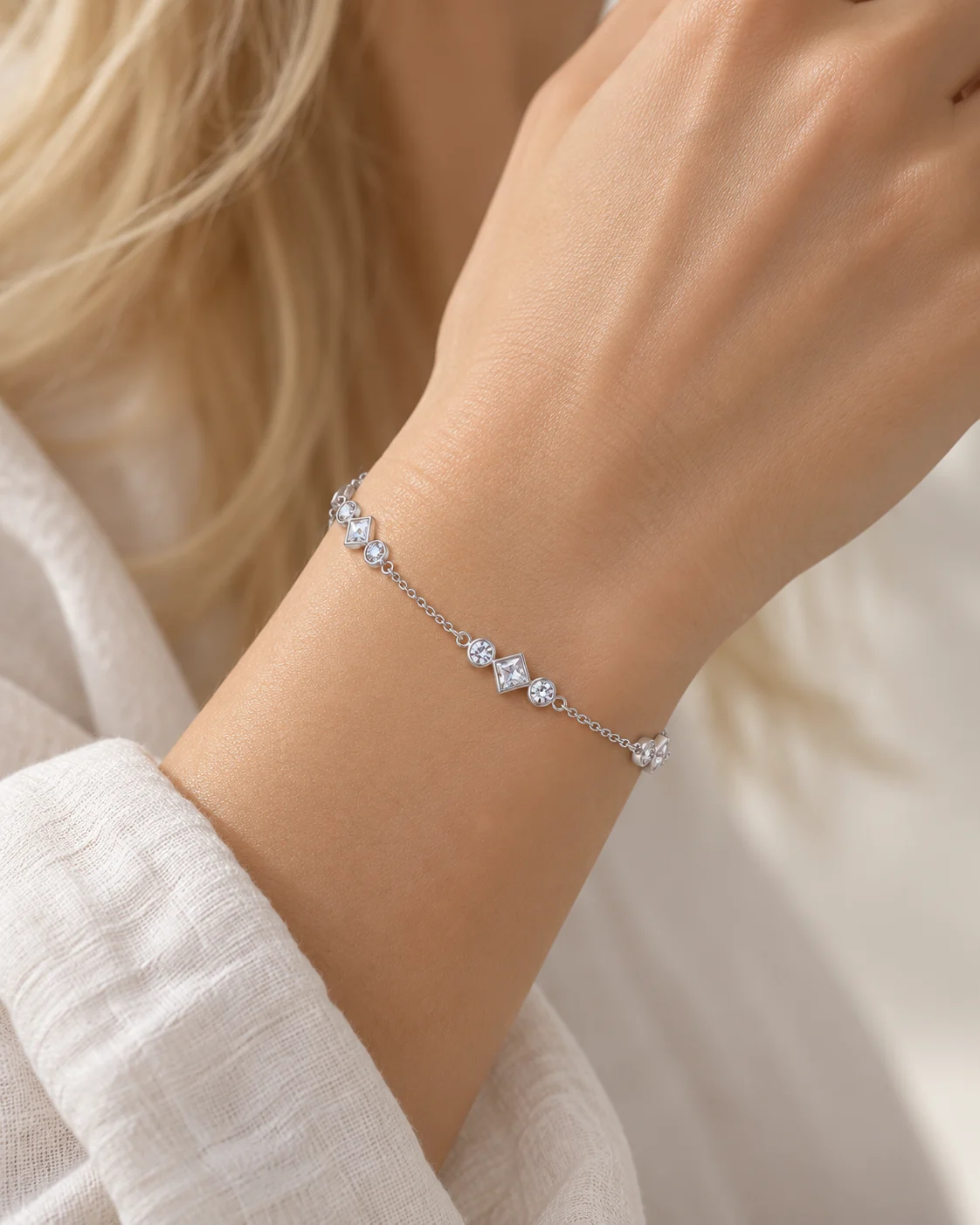 Bracelet mini maille portugaise, zircons carrés et ronds, finition argentée, porté, vu de près