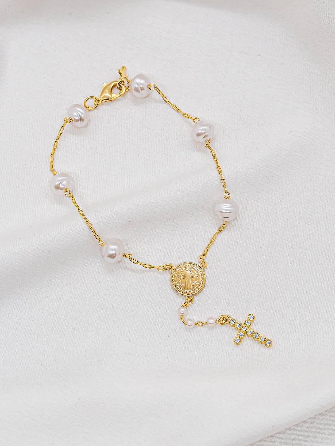 Bracelet doré à perles blanches irrégulières, médaille de Saint Benoît et croix sertie