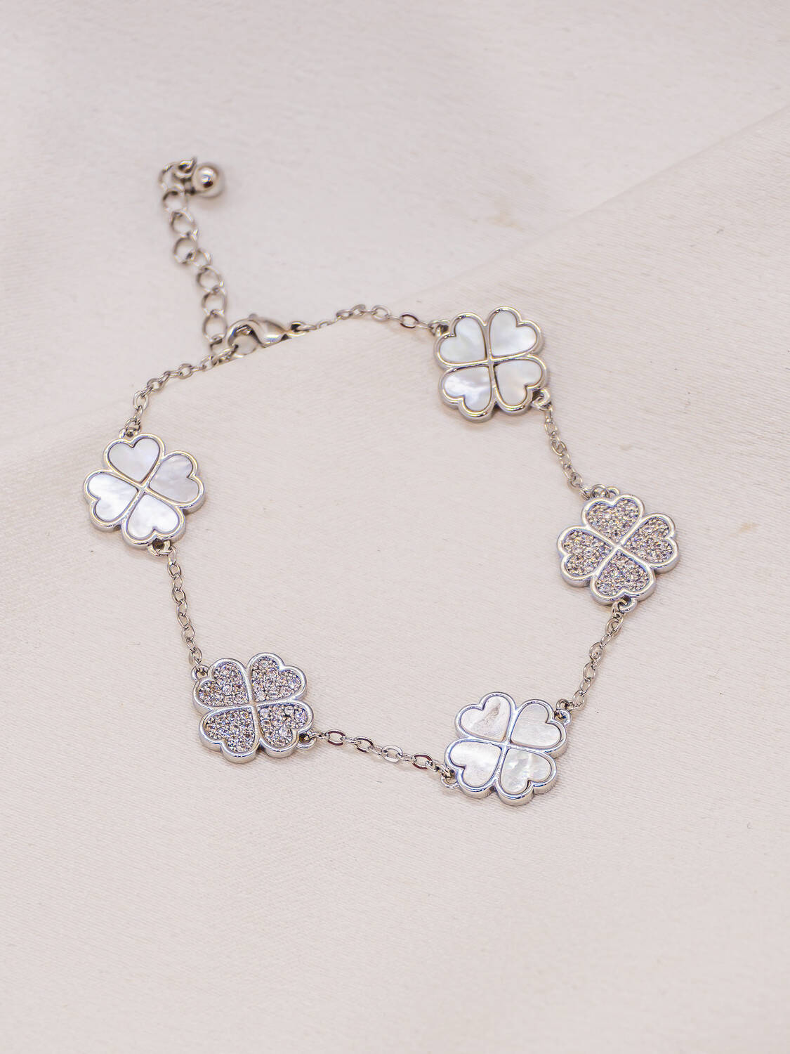 Bracelet argenté de cinq trèfles en nacre et en pierres claires sur fine chaîne