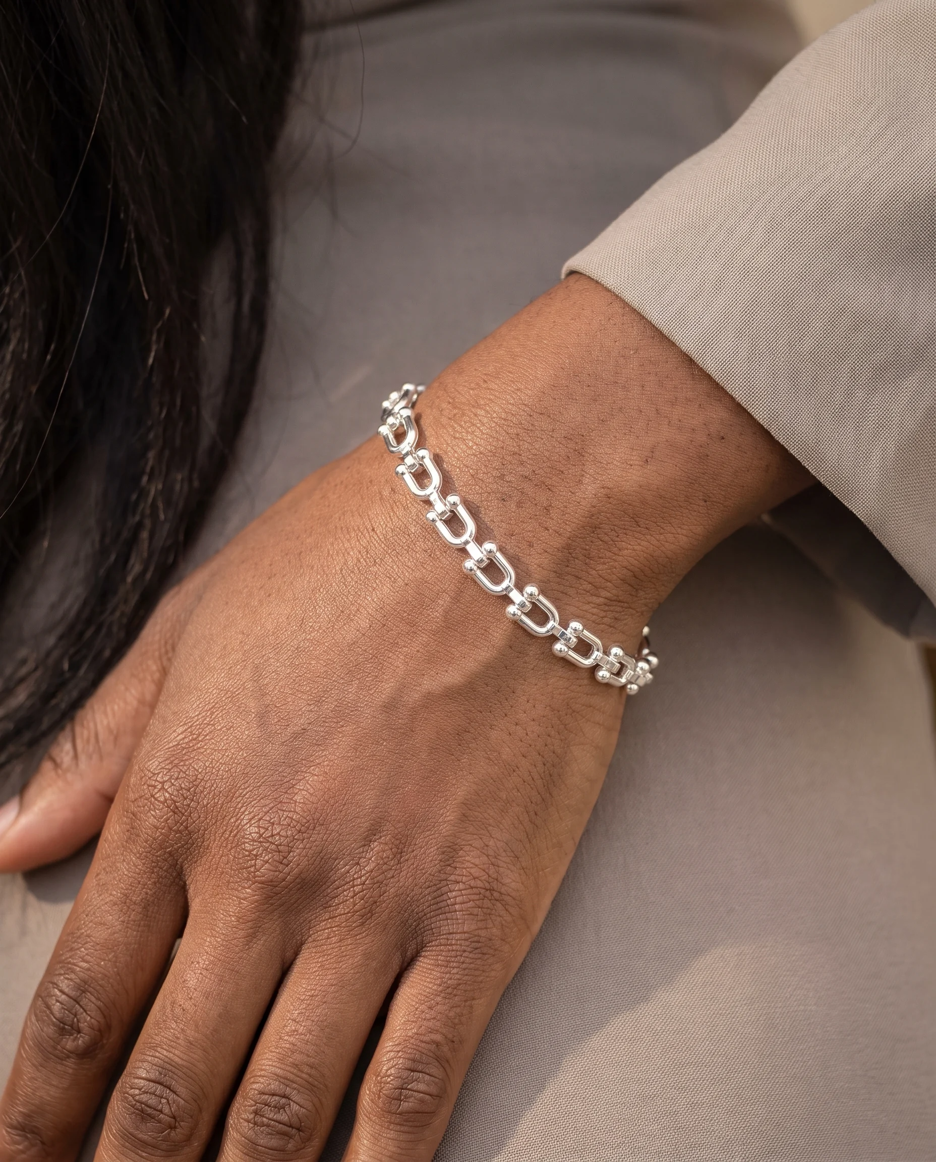 Bracelet mini maillons U, petites boules finition argentée, porté au poignet, vu de près