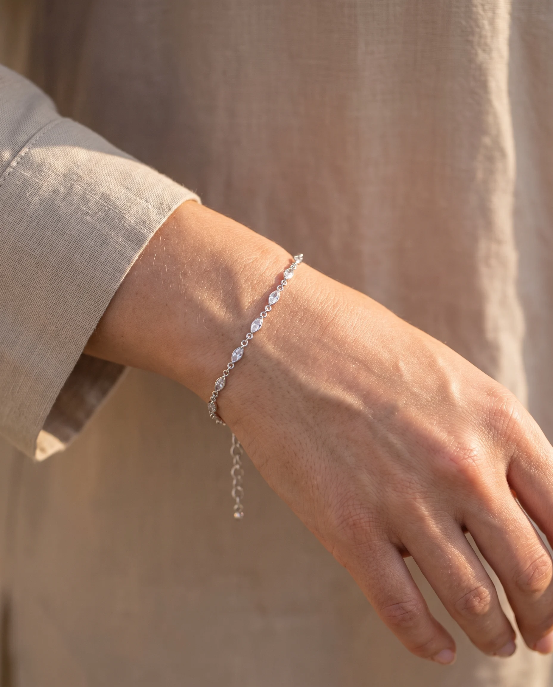 Bracelet mini maillons, zircons navette finition argentée, porté au poignet, vu de près