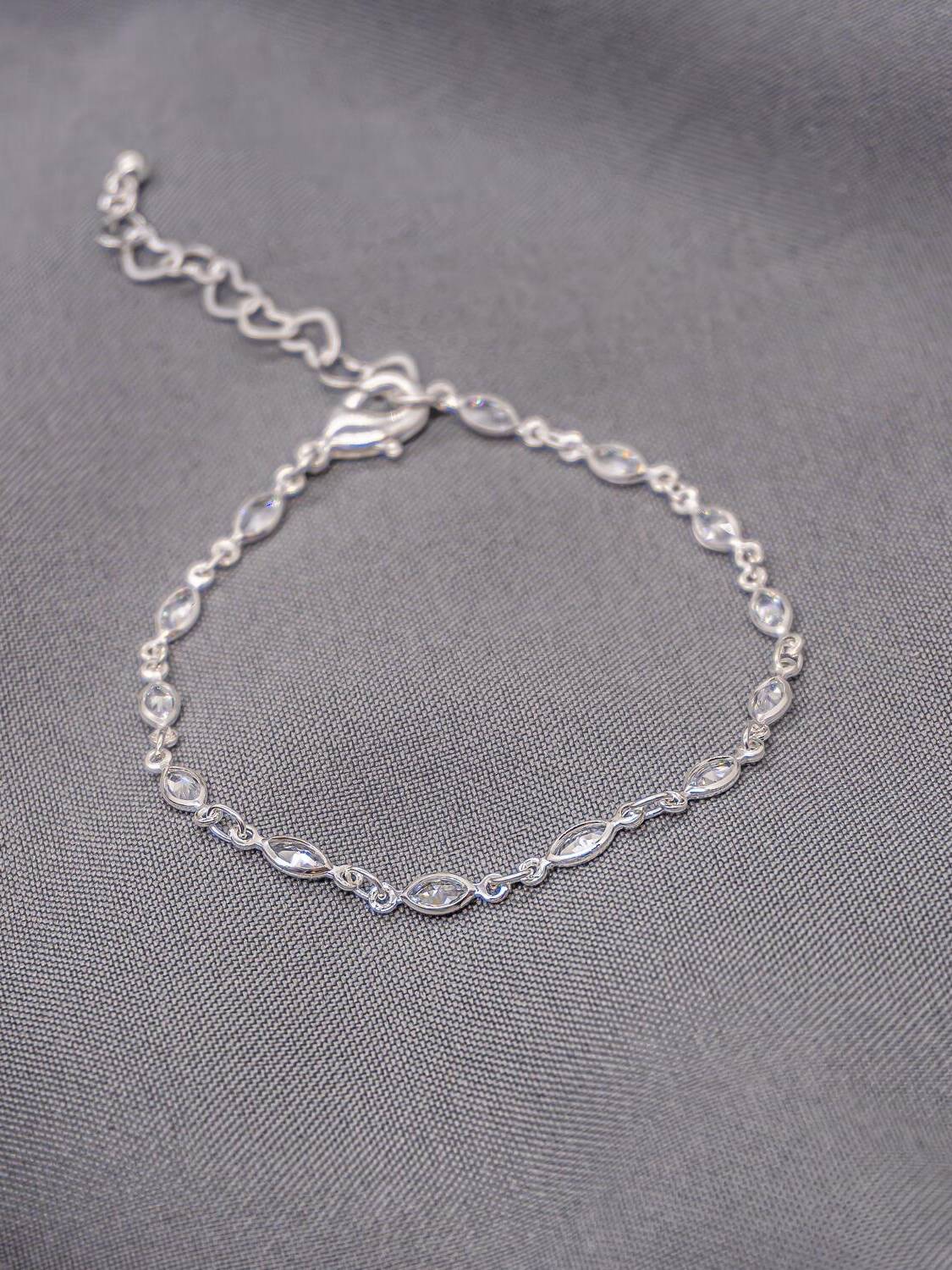 Bracelet argenté à petits maillons, pierres claires en navette serties, chaînette d’extension