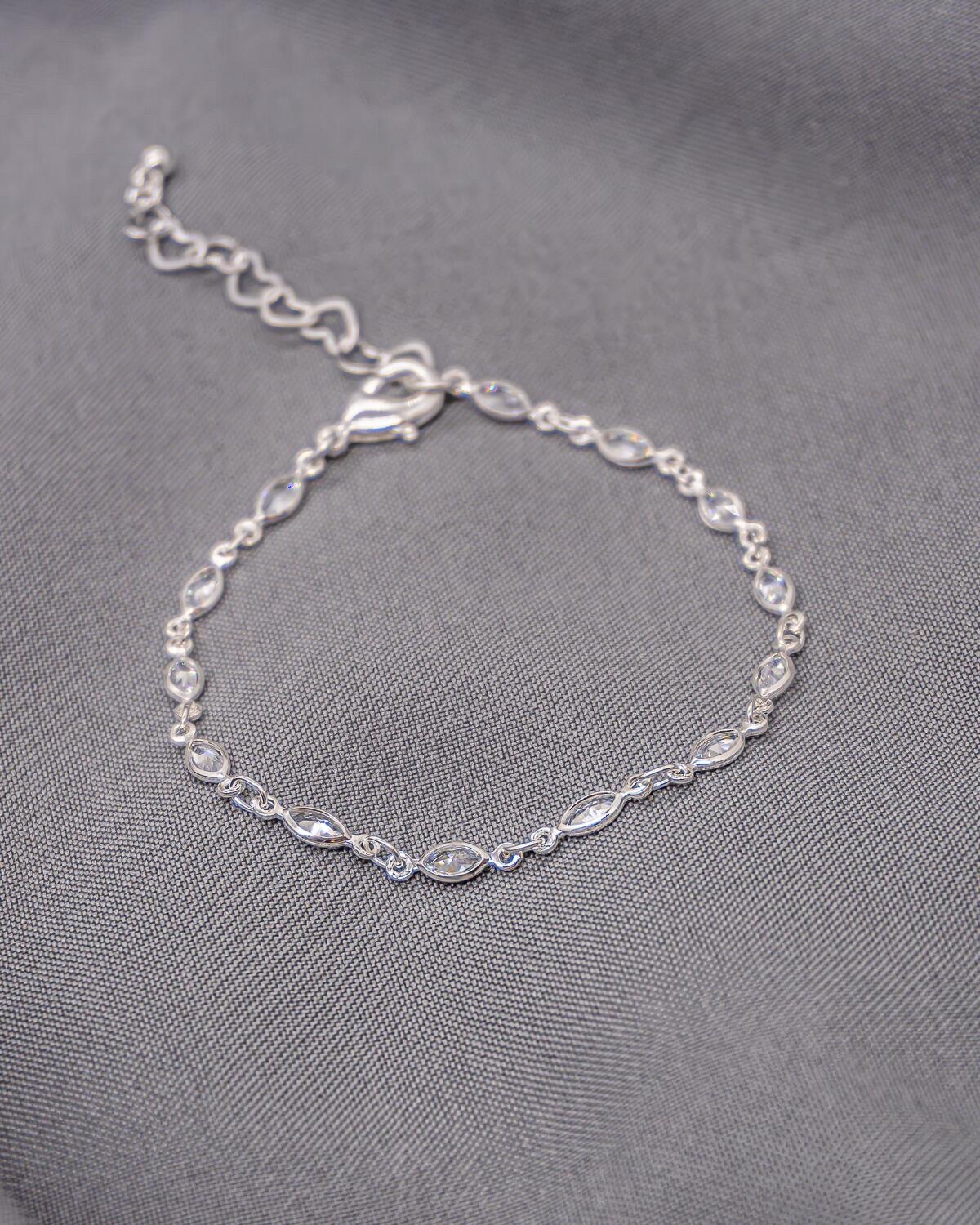 Bracelet argenté à petits maillons, pierres claires en navette serties, chaînette d’extension