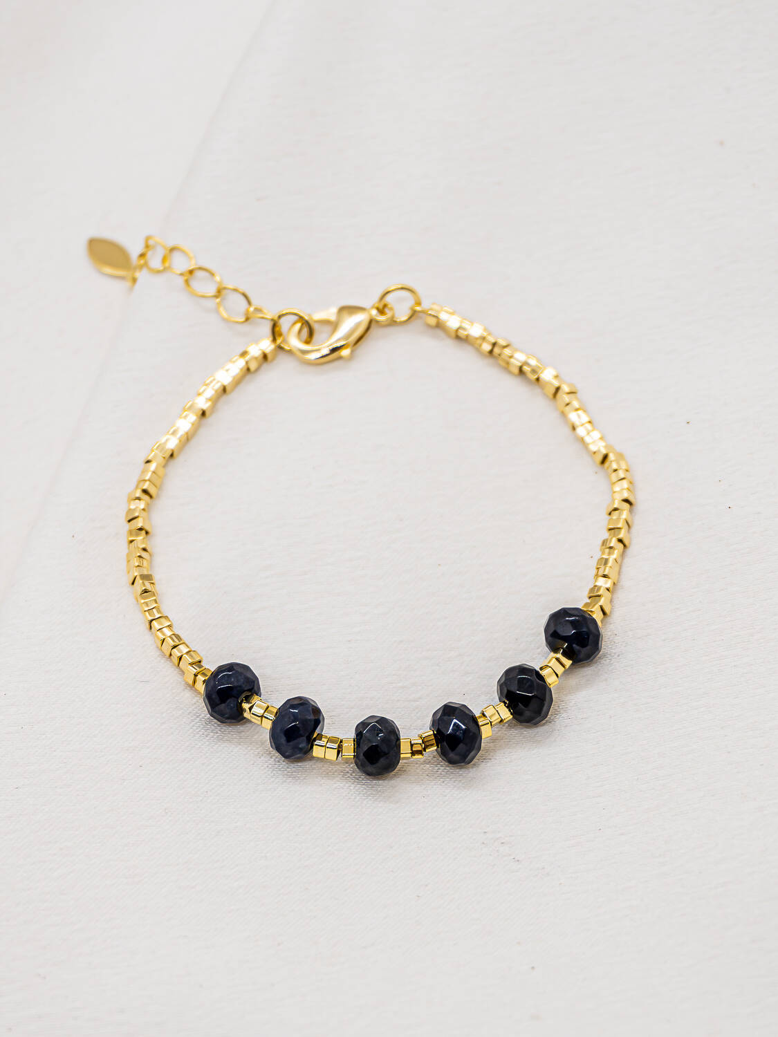 Bracelet doré de petites perles tubes avec six perles facettées bleu nuit