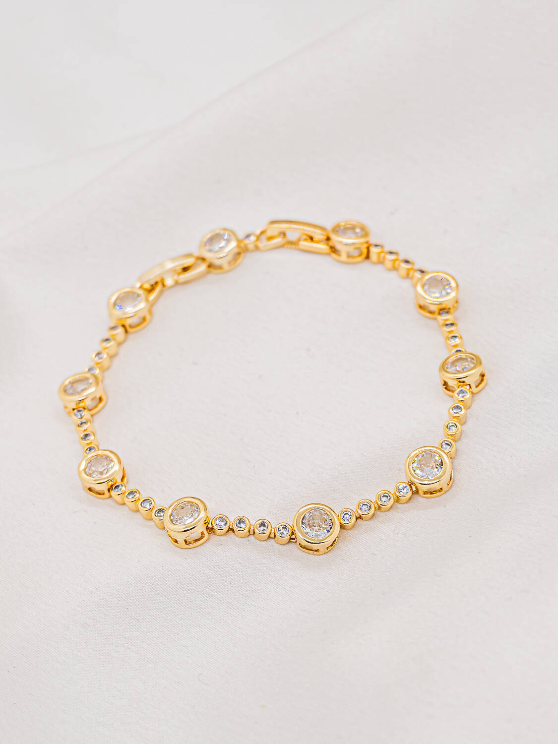 Bracelet doré alternant grosses pierres claires rondes serties et chaînette de minuscules pierres