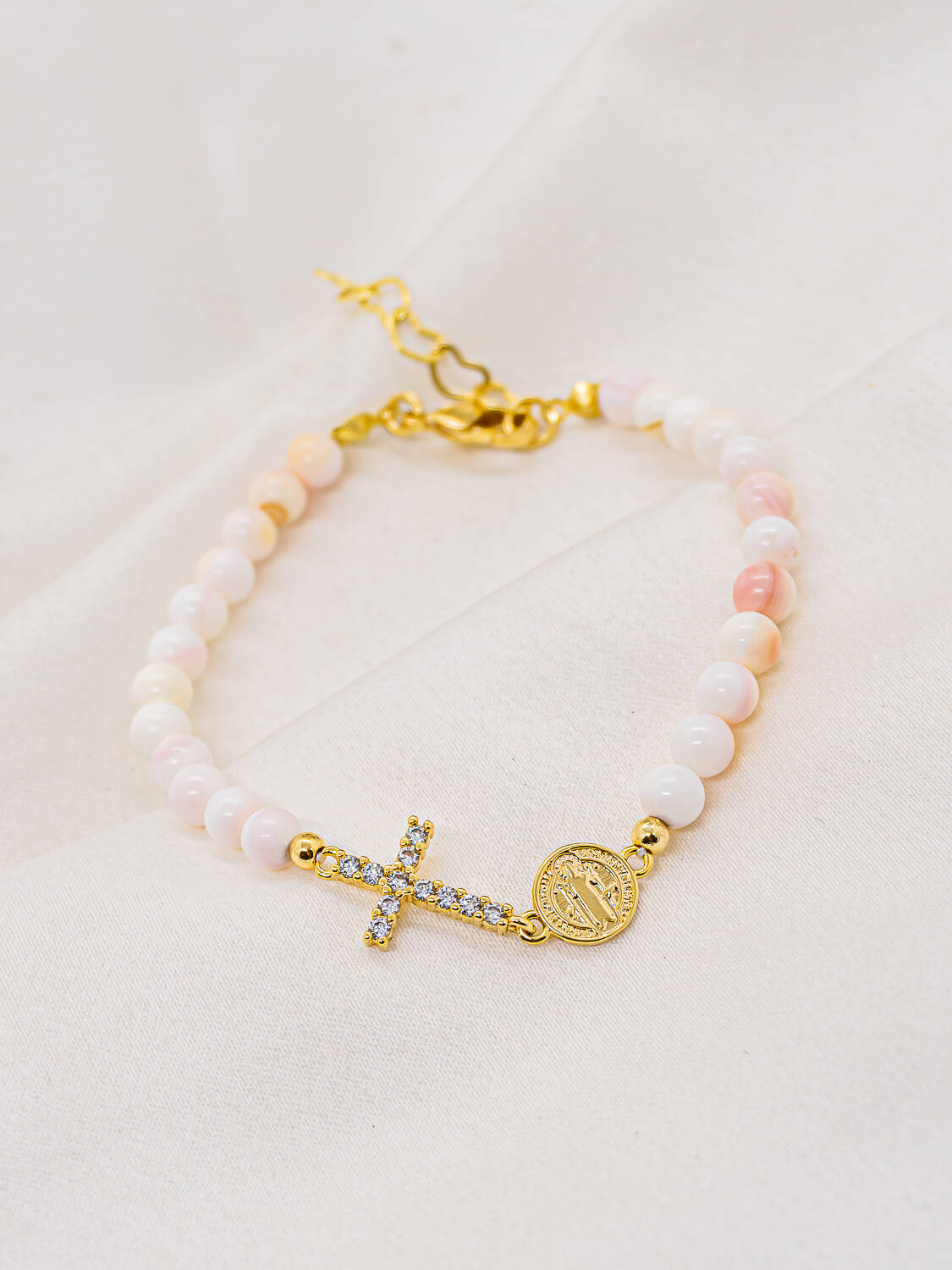 Bracelet de perles nacrées rose et blanc avec croix sertie dorée et médaille ronde