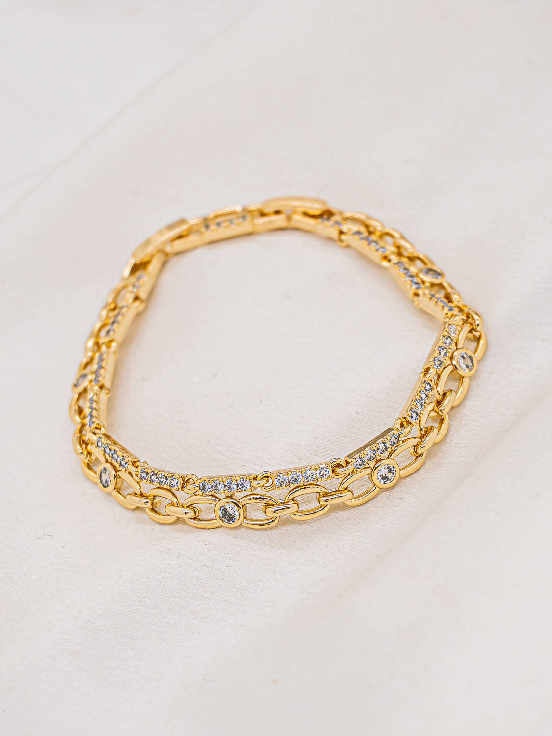 Bracelet doré à deux rangs, maillons ovales ajourés et petites barres serties de pierres claires