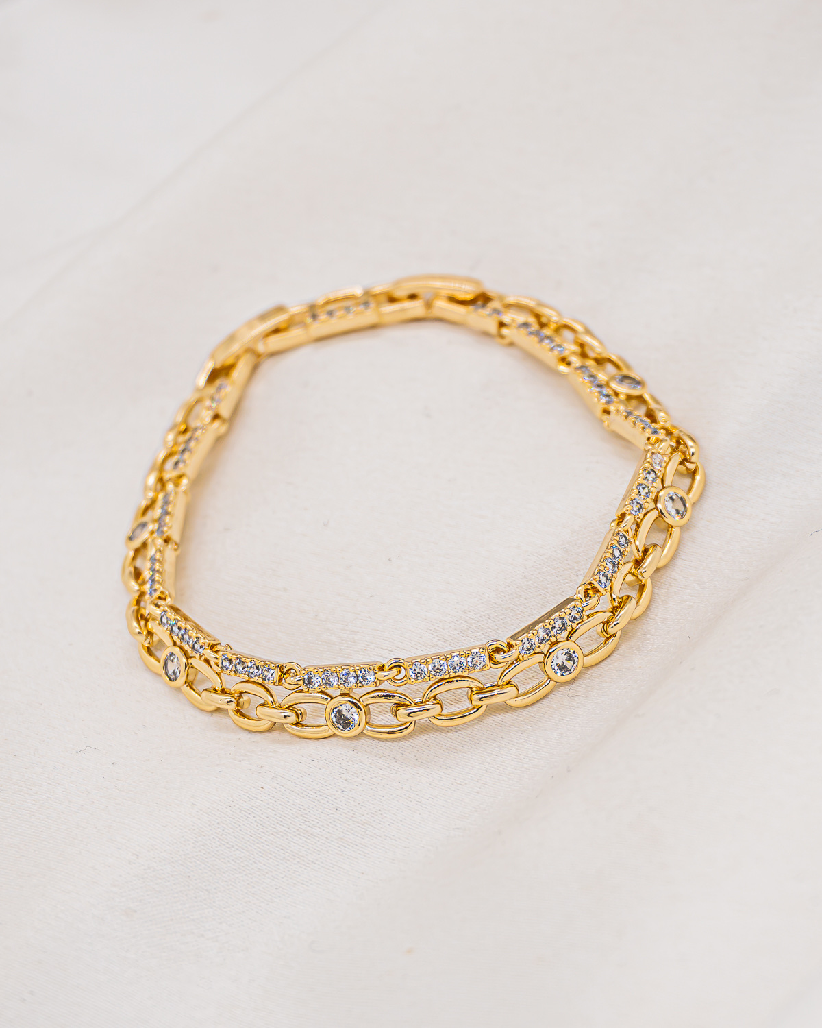 Bracelet doré à deux rangs, maillons ovales ajourés et petites barres serties de pierres claires