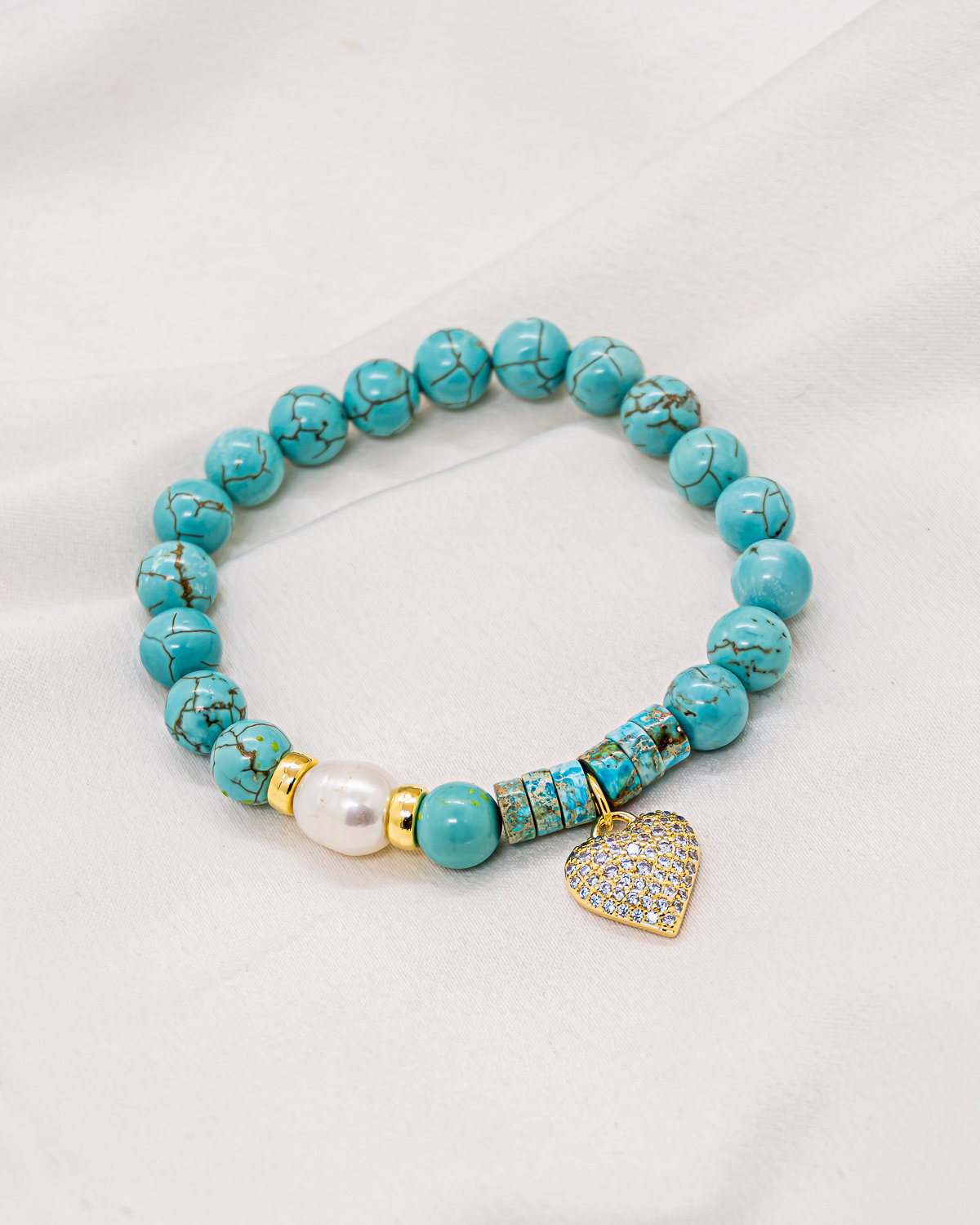 Veined turquoise bead bracelet with a white pearl and a pavé-set gold heart