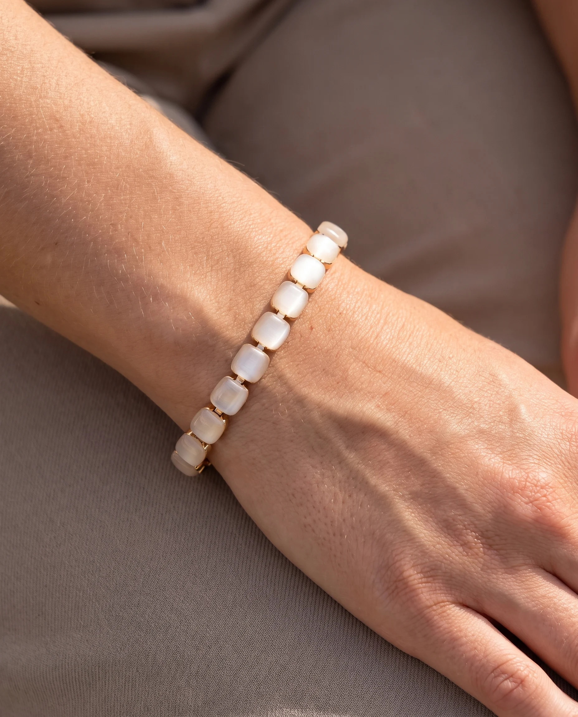 Bracelet pierres carrées œil de chat, porté au poignet, vu de près