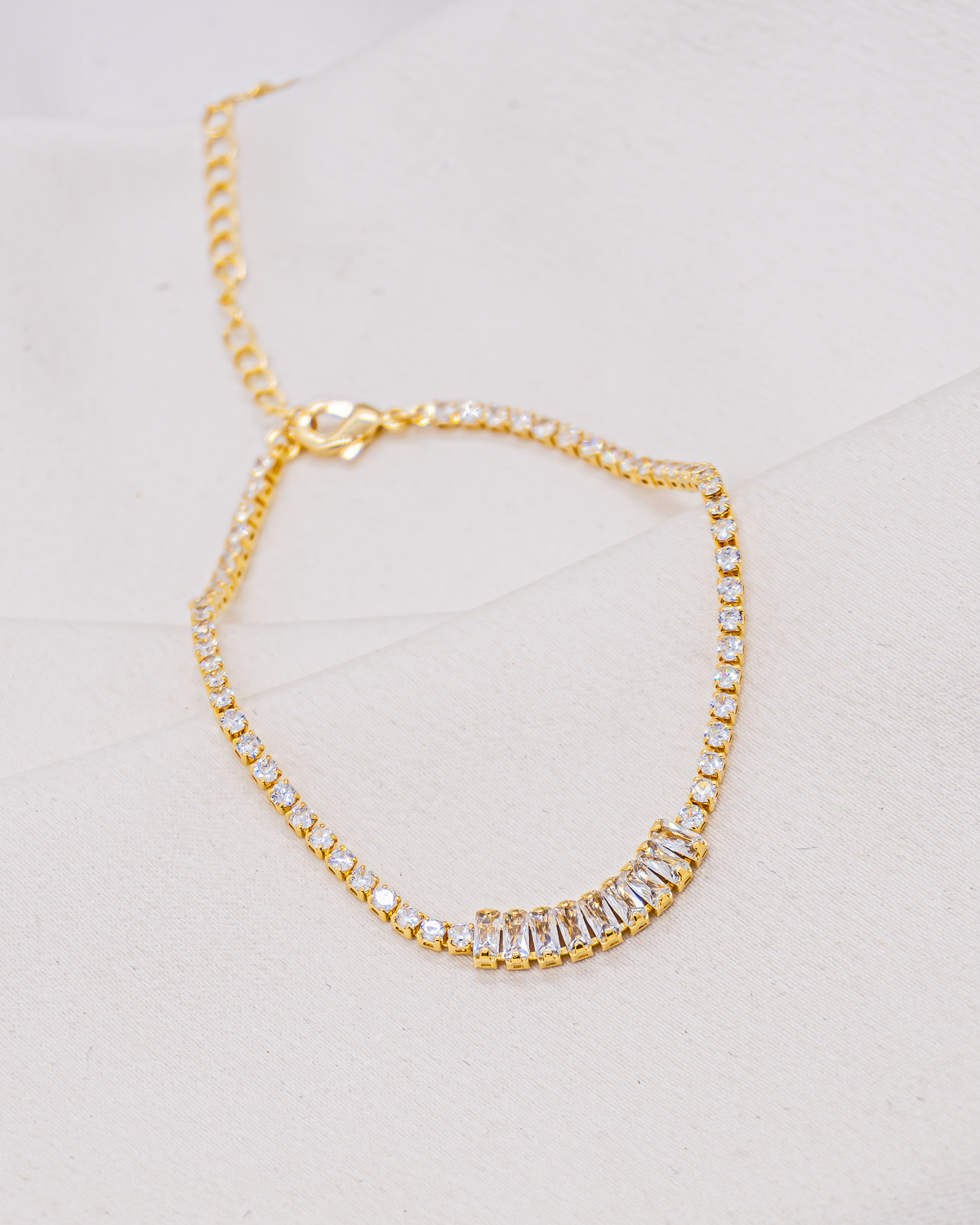 Bracelet rivière doré de pierres claires rondes, avec des pierres baguette au centre