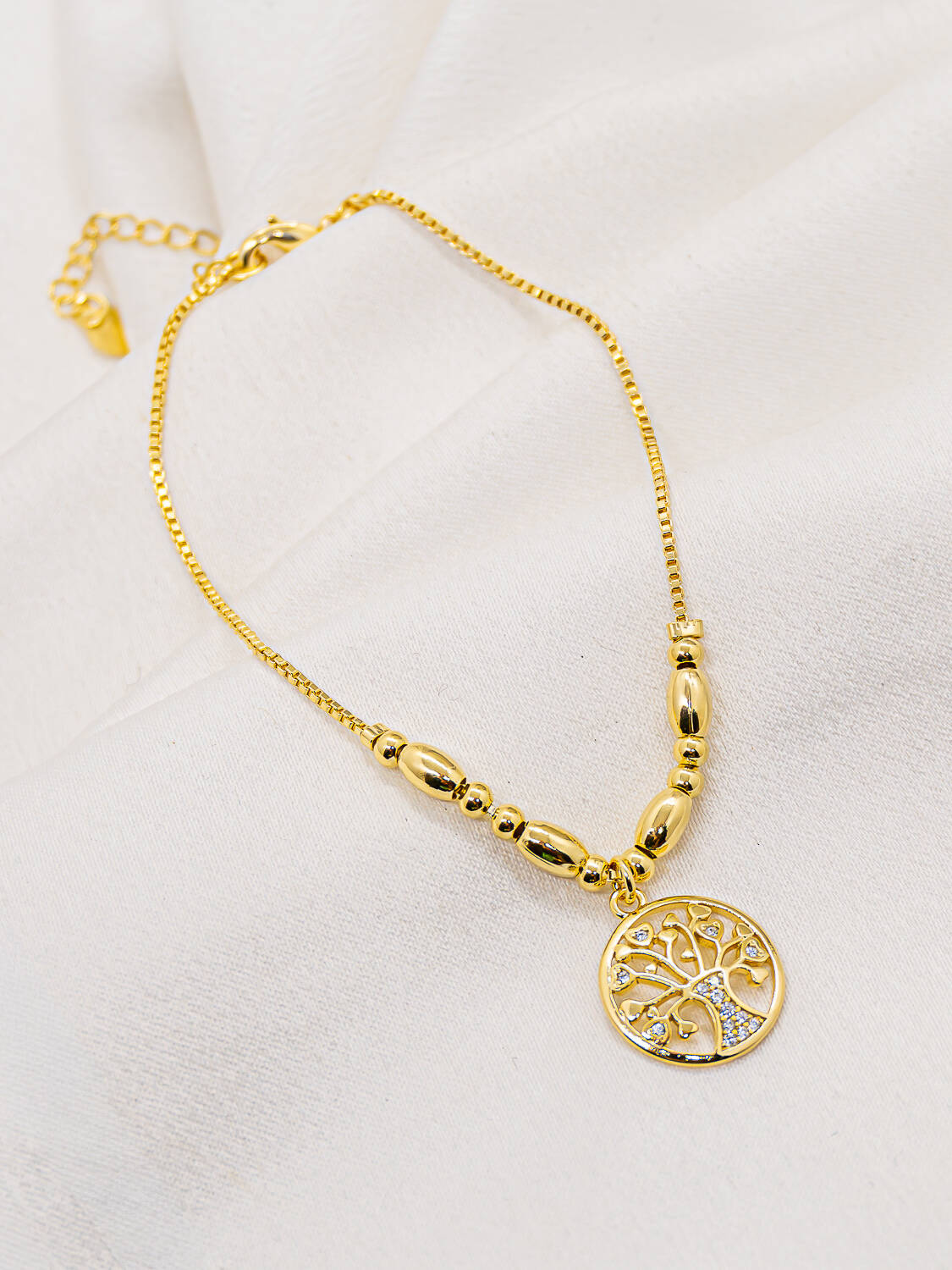 Bracelet doré fin avec petites billes lisses et médaillon rond ajouré en arbre de vie