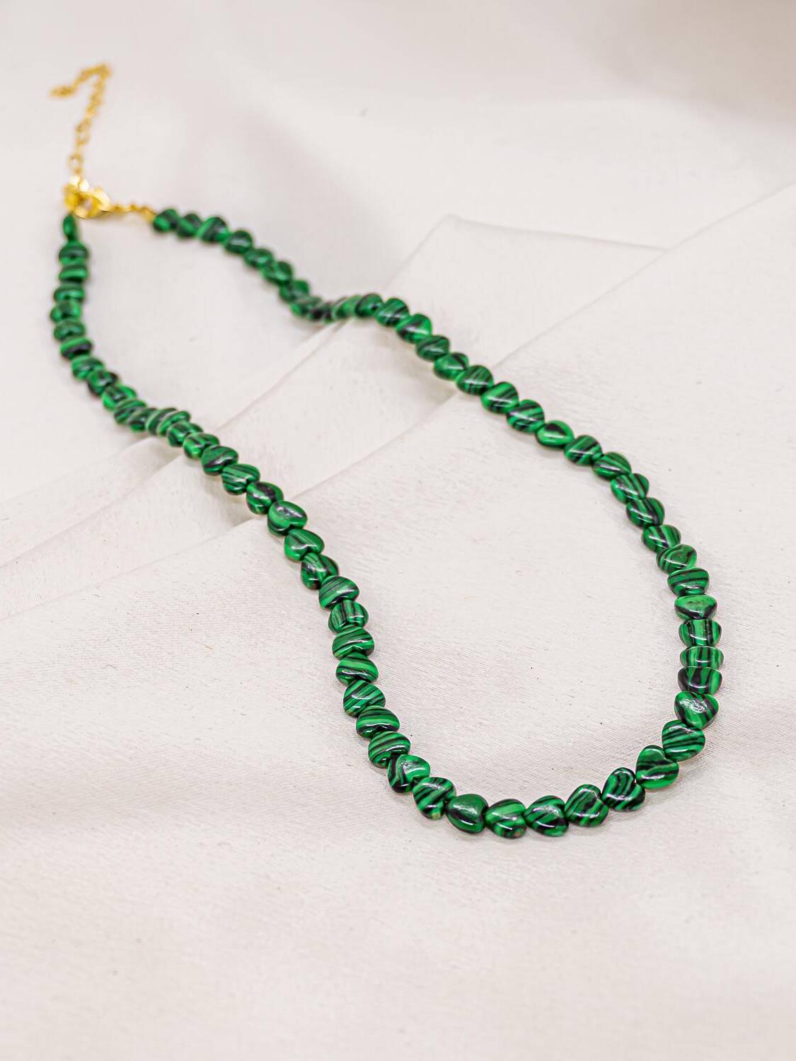 Collier de petits cœurs verts veinés de noir avec fermoir et chaînette dorés