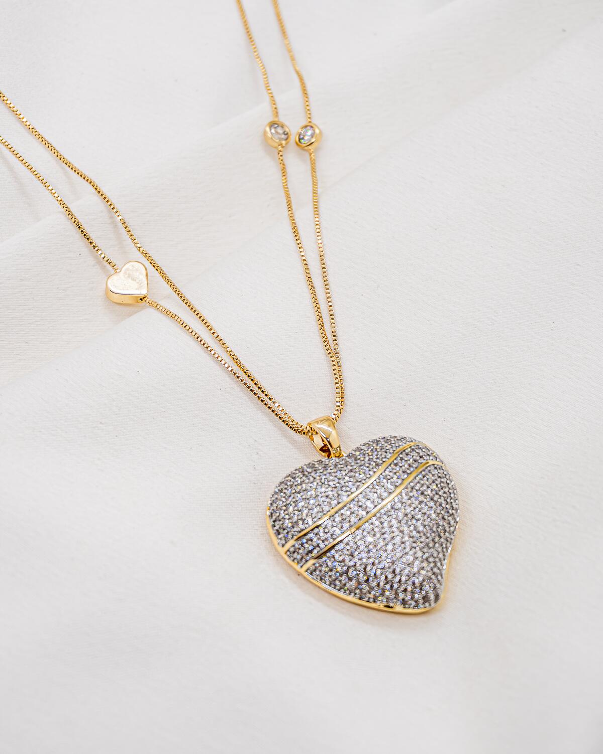Collier à deux fines chaînes, petit cœur lisse et grand cœur serti de pierres claires