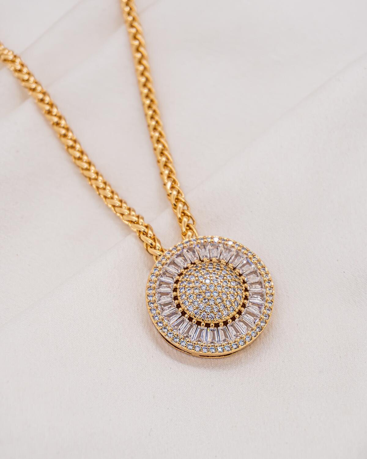 Collier doré à maille tressée, large pendentif rond serti de pierres claires et de baguettes