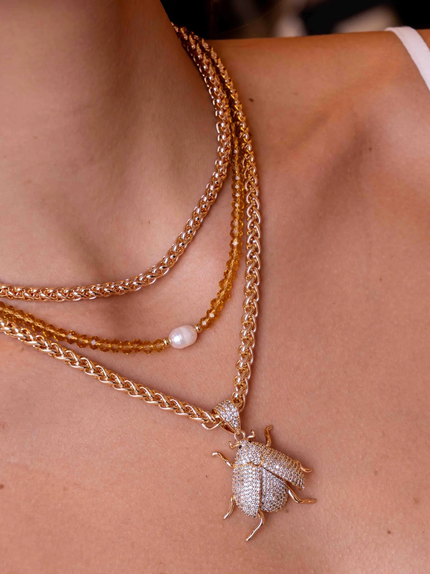Collier entrelacé, scarabée serti, porté en gros plan