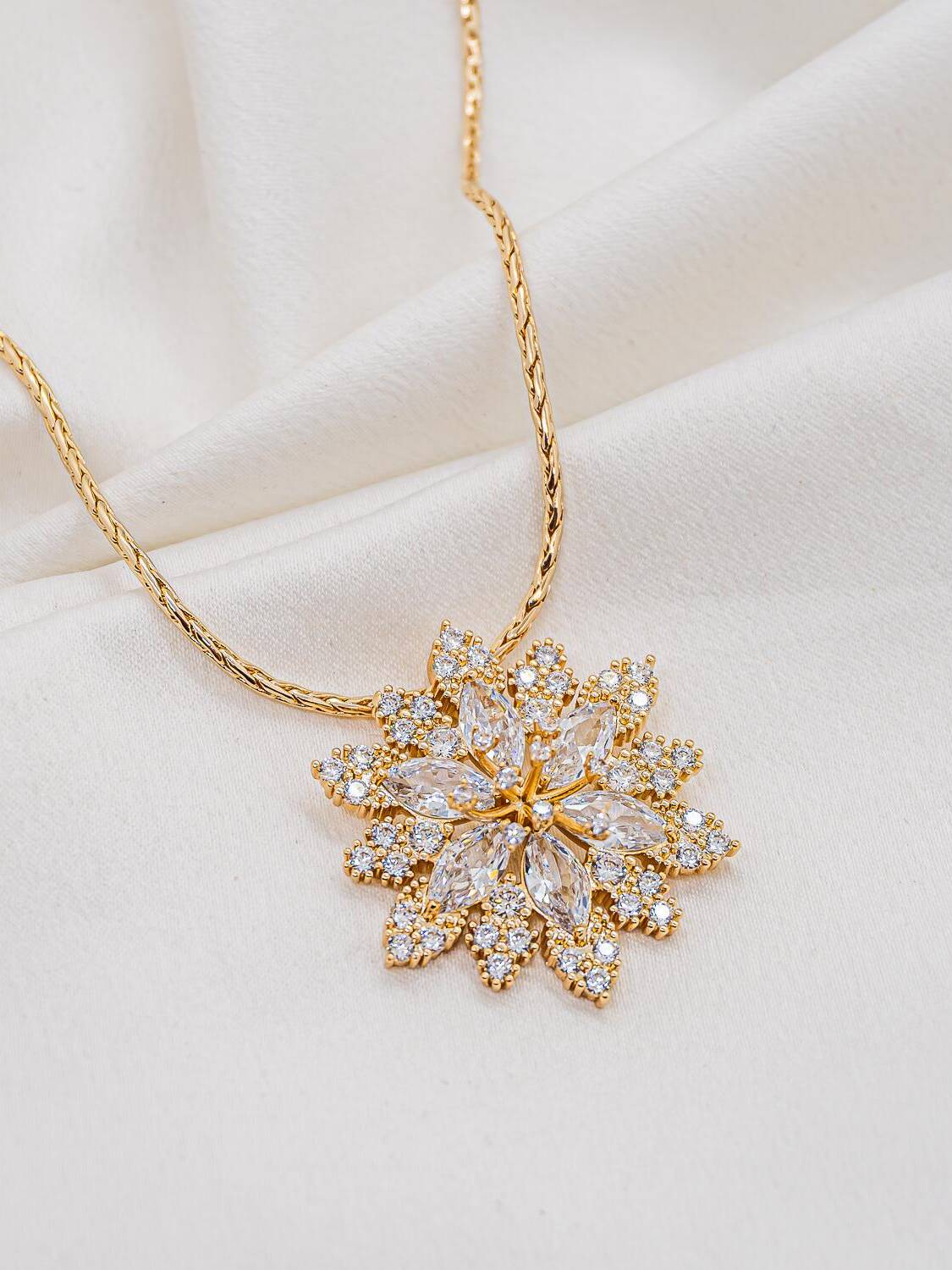 Collier doré à large pendentif en fleur de zircons navette entourés de petites pierres rondes