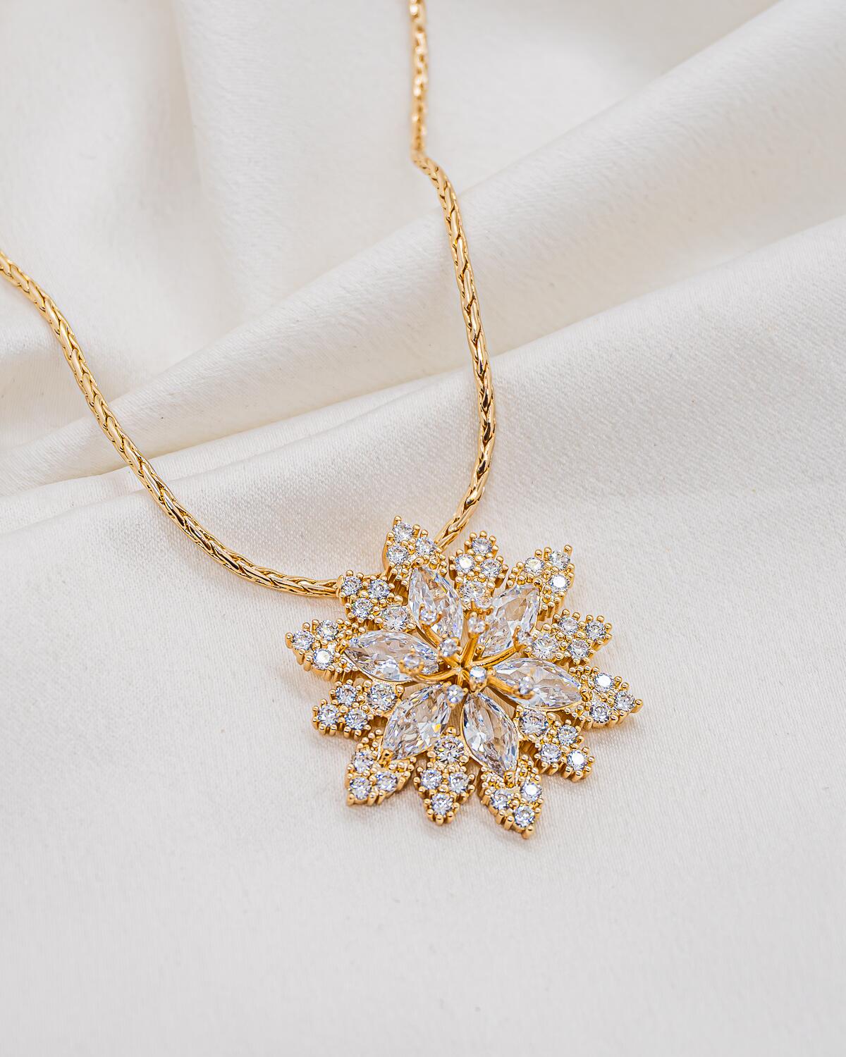 Collier doré à large pendentif en fleur de zircons navette entourés de petites pierres rondes